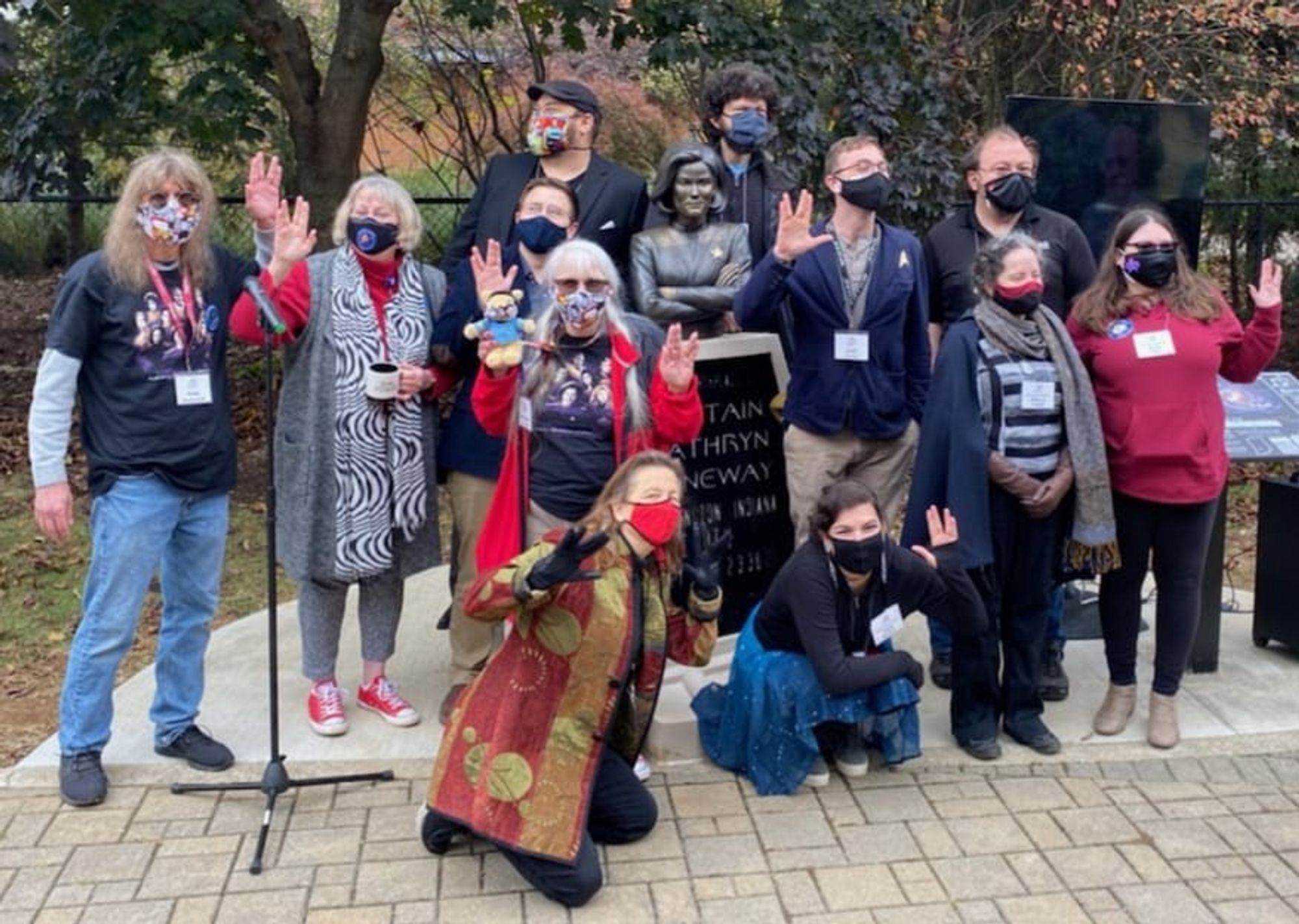 A group of older individuals pose, masked, for a photo. 