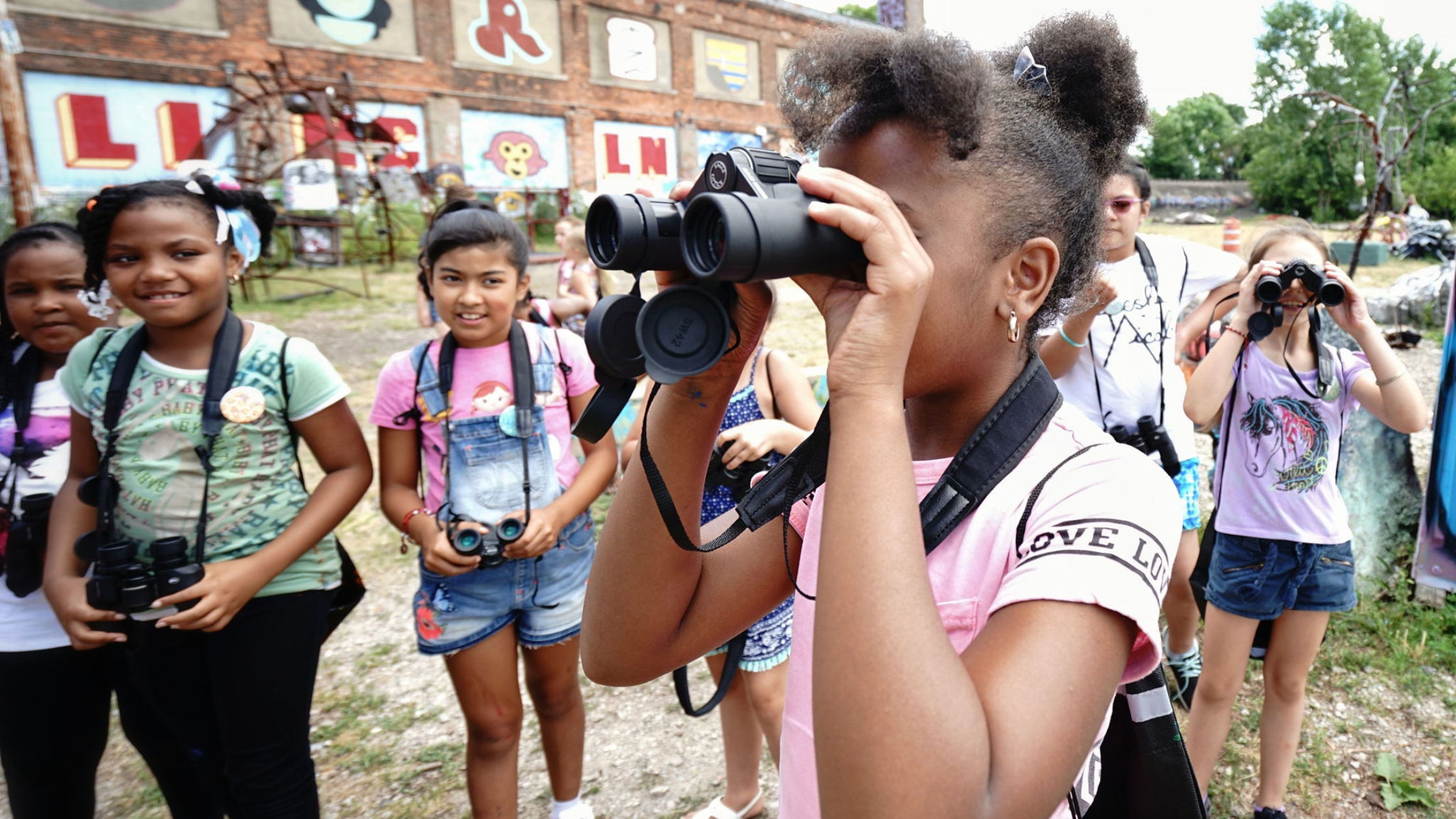 A group of young girls use binoculars at Lincoln Street Art Park and Activi-Tree Learning Center 