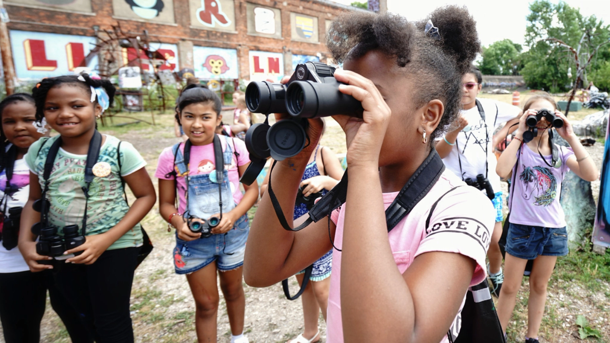 A group of young girls use binoculars at Lincoln Street Art Park and Activi-Tree Learning Center