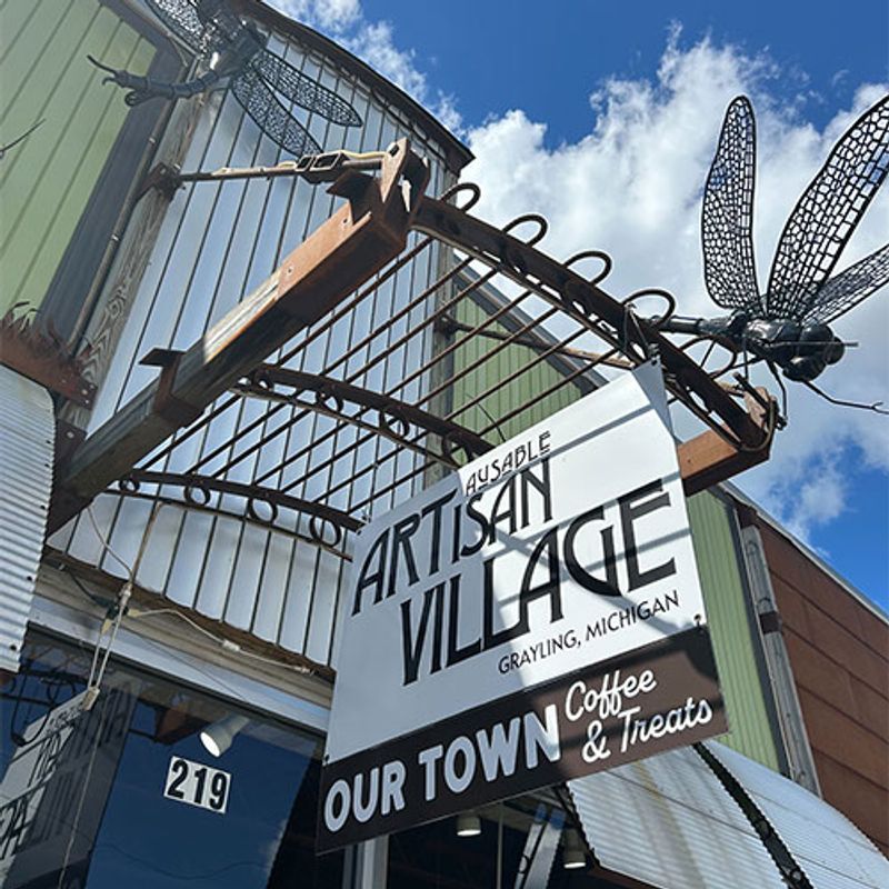 A handmade sign and awning above the door to the AuSable Artisan Village in Grayling, Michigan.