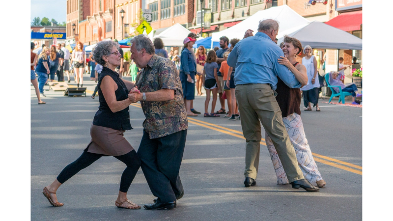 St. Johnsbury Final Fridays event series with older couple's dancing together in the street.