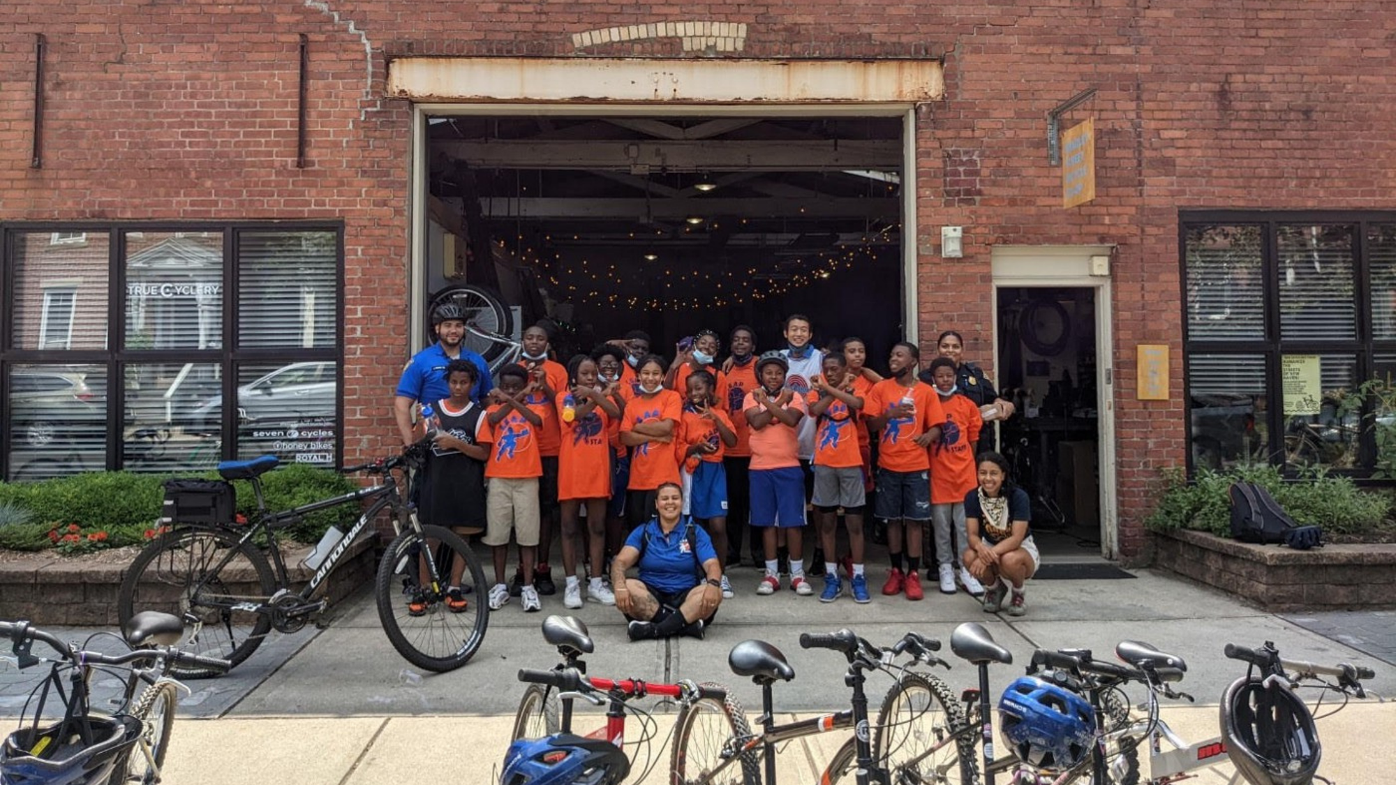 A group of kids receiving bicycles. 
