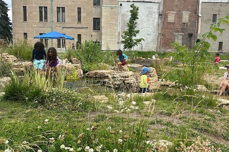 Children explore the nature playscape pond and greenspace. 