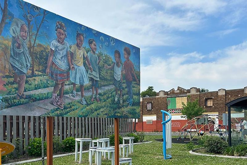 A park in the NW Goldberg Neighborhood in Detroit, Michigan, featuring public art, seating, and play space.