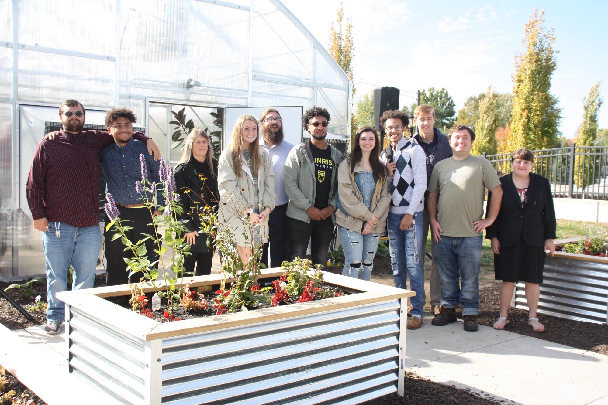 Students gather around the greenhouse with pride having participated in making it happen.
