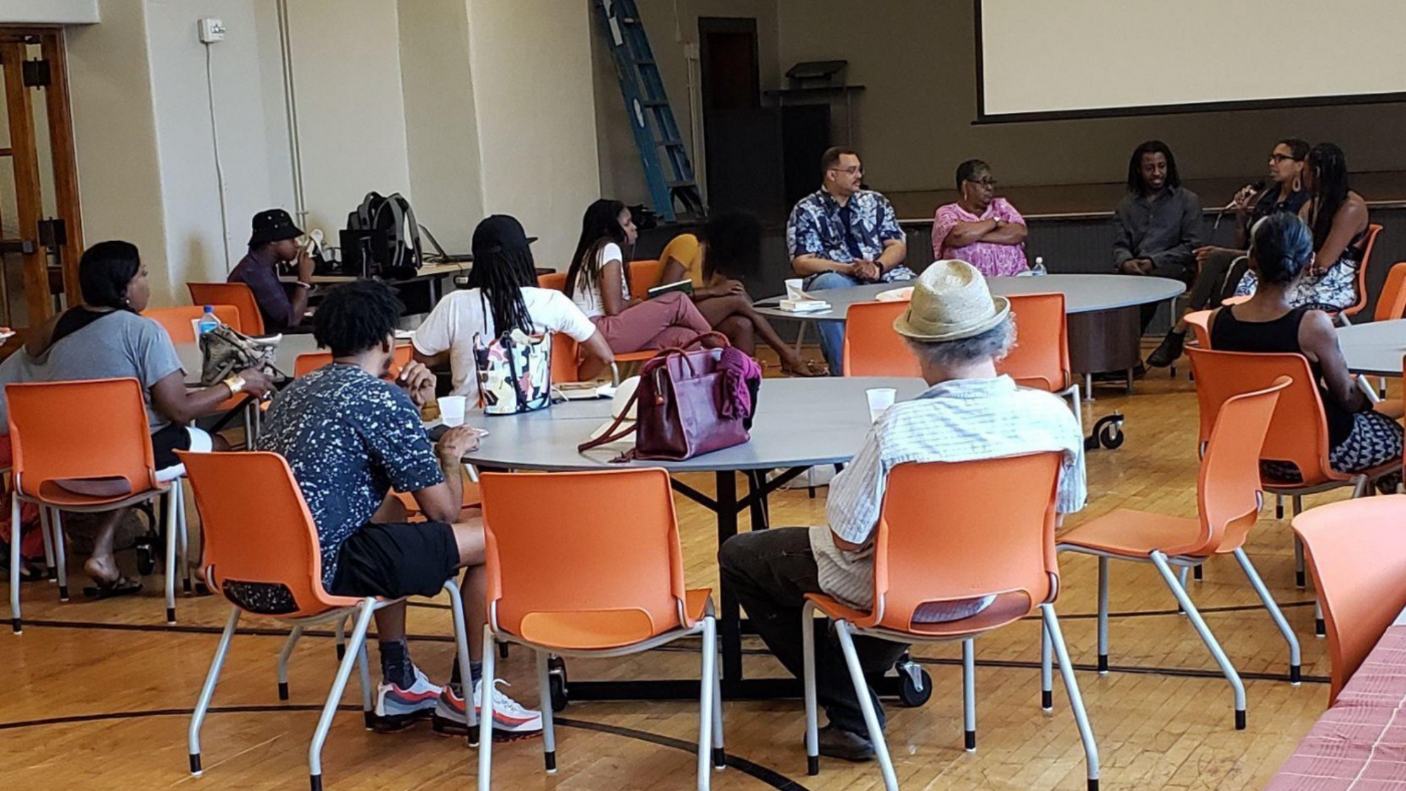 A group of Indy residents sit around tables for a community discussion