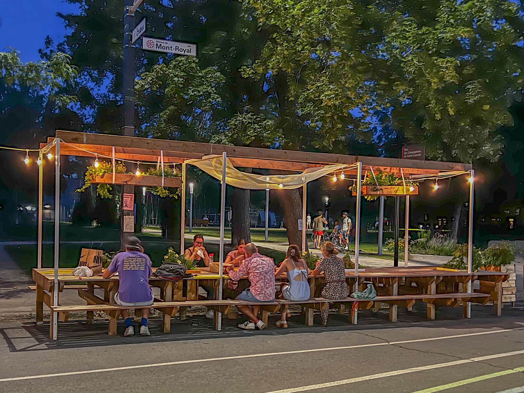 Residents sit at the "Feeding Table," a table installation along Mont-Royal Aveune