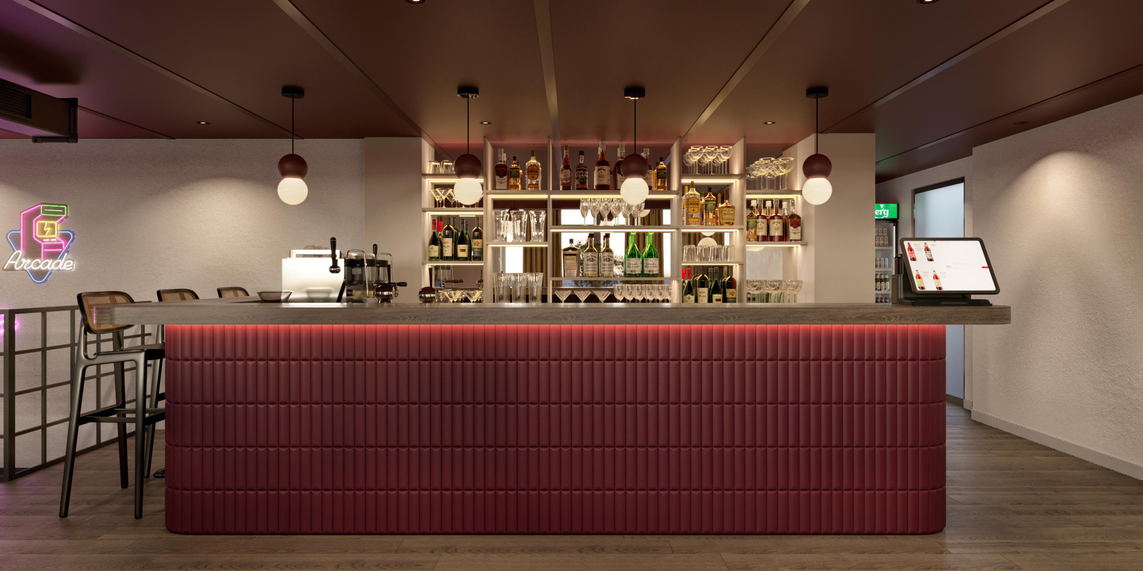Bar with a burgundy fluted counter, backlit shelves and pendant lights