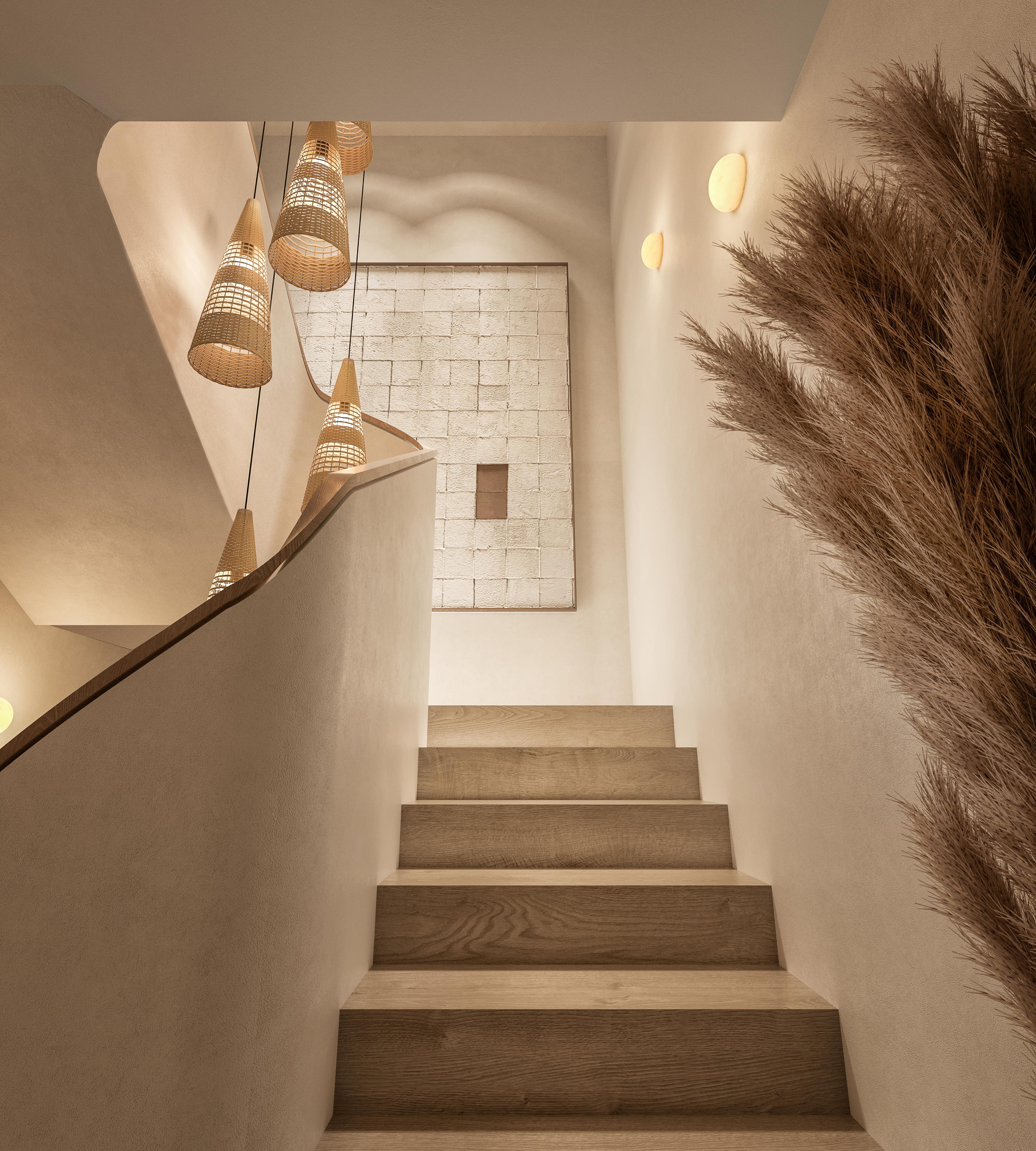Staircase to the first floor with rattan pendant lights and dried pampas grass