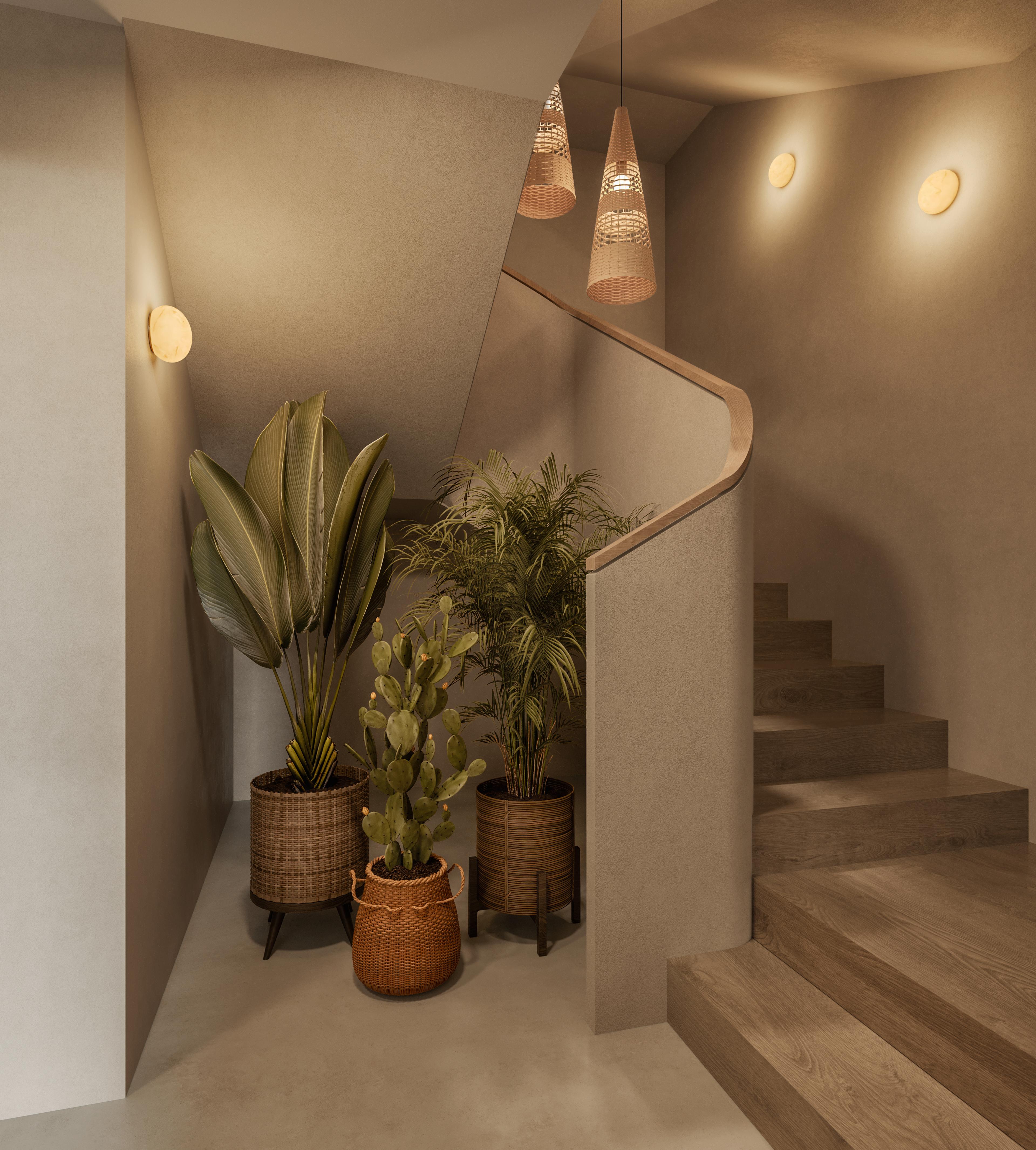 Basement stairwell with a curved handrail, wall lights and large potted plants