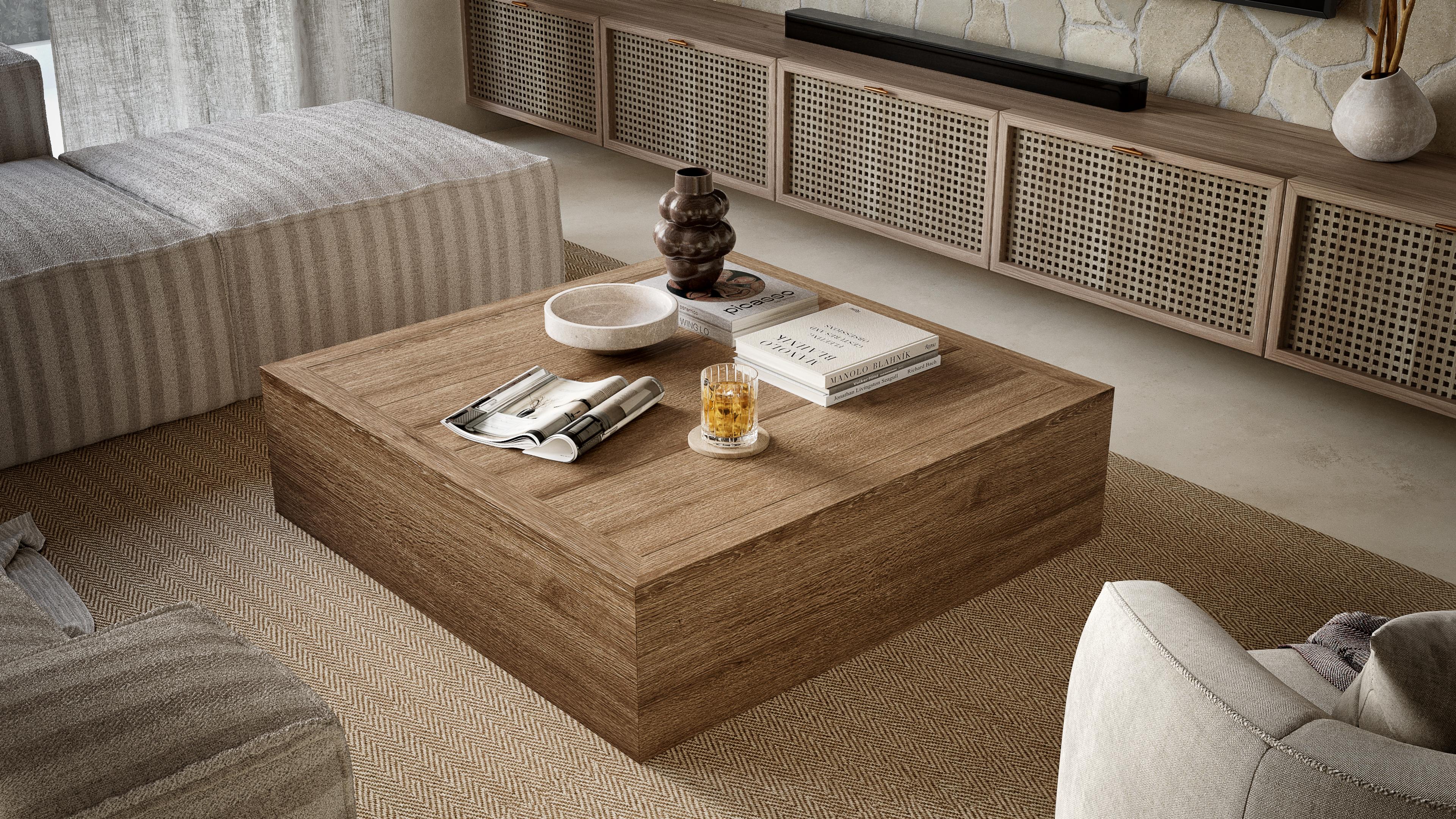 Square timber coffee table in front of a rattan-fronted media unit and a stone wall