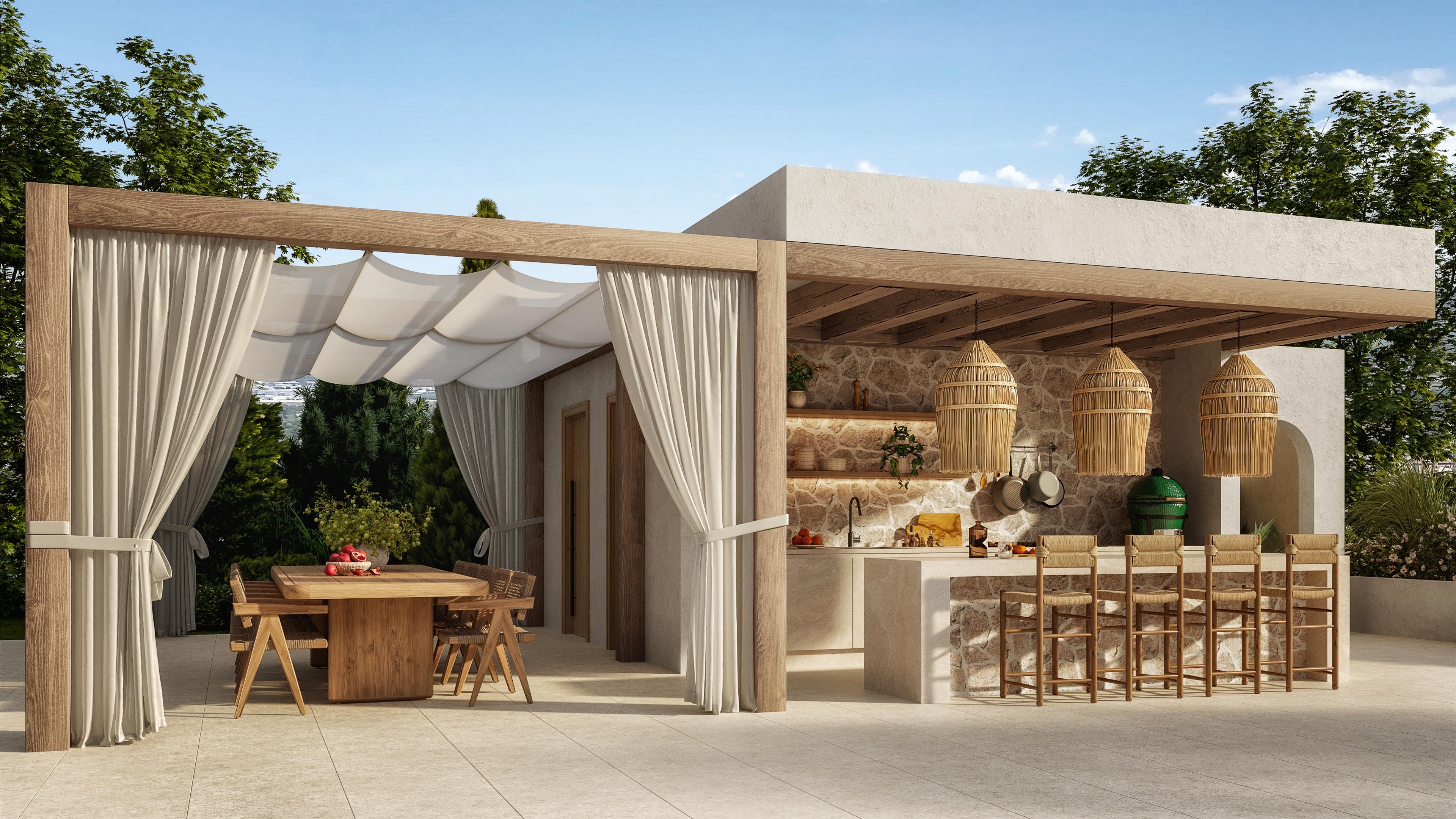 Outdoor kitchen under a timber pergola with linen drapes and a long dining table
