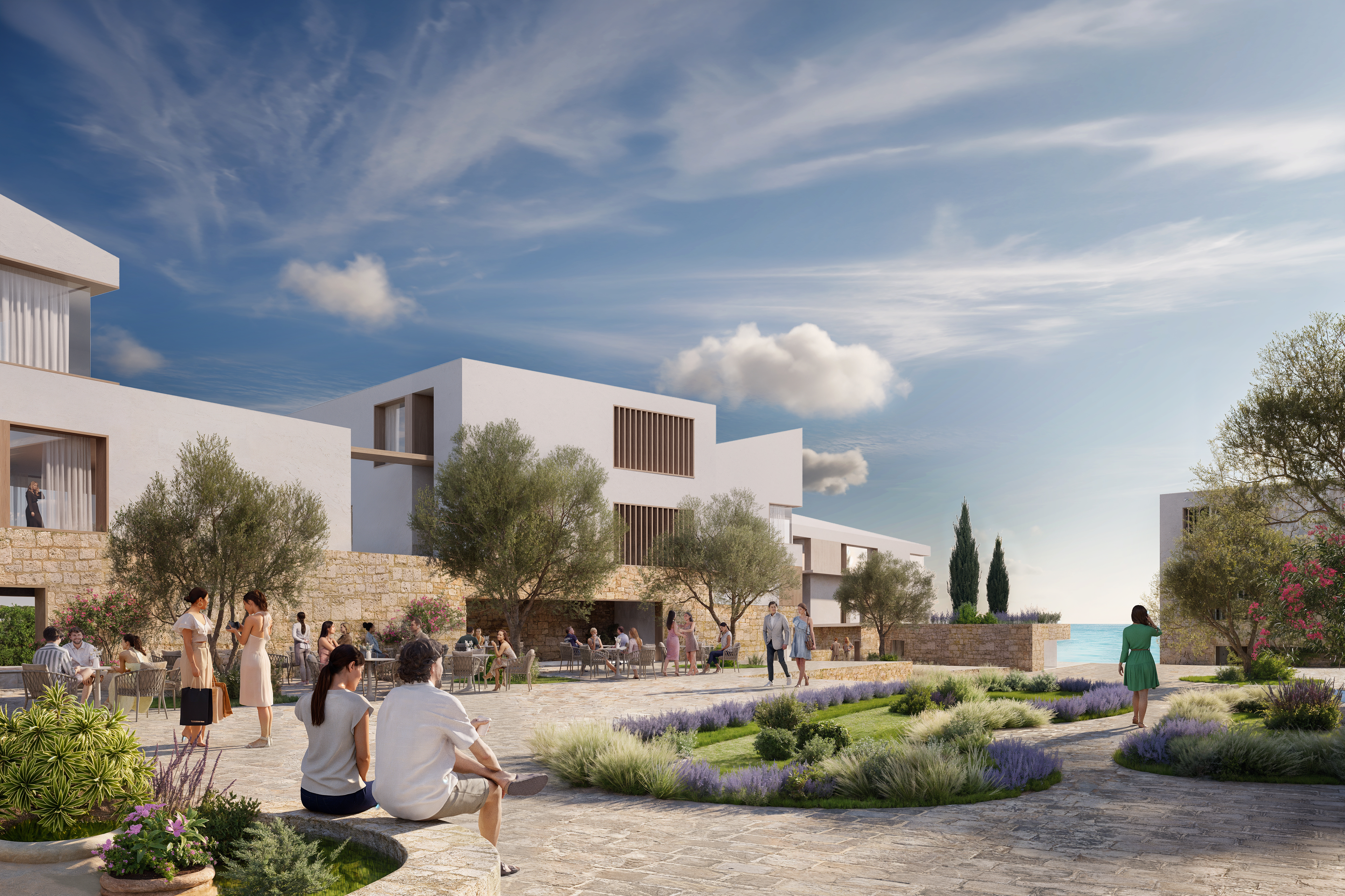 Courtyard between white and stone houses with people seated among lavender and olive trees
