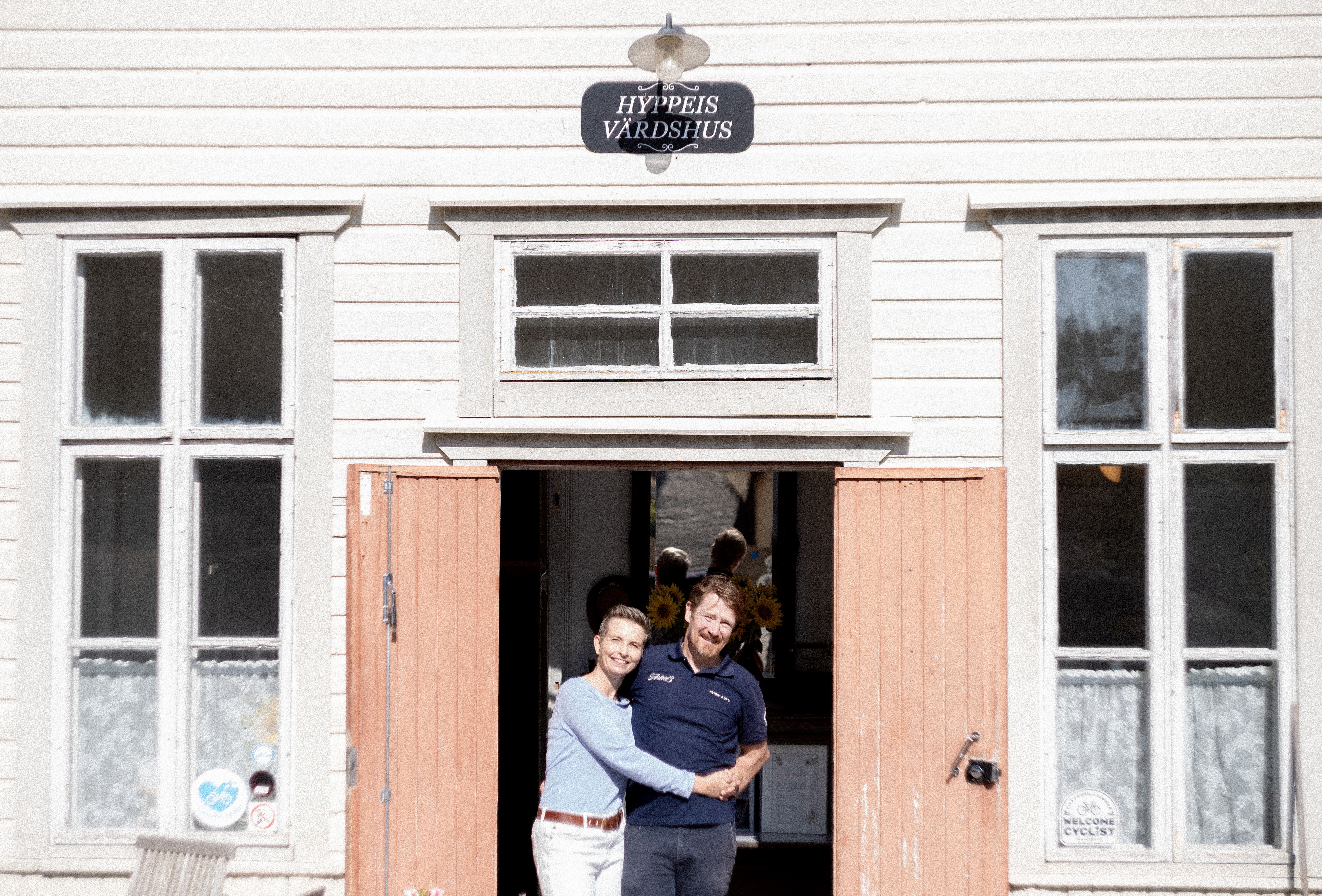 Hotel owners standing in a doorway.