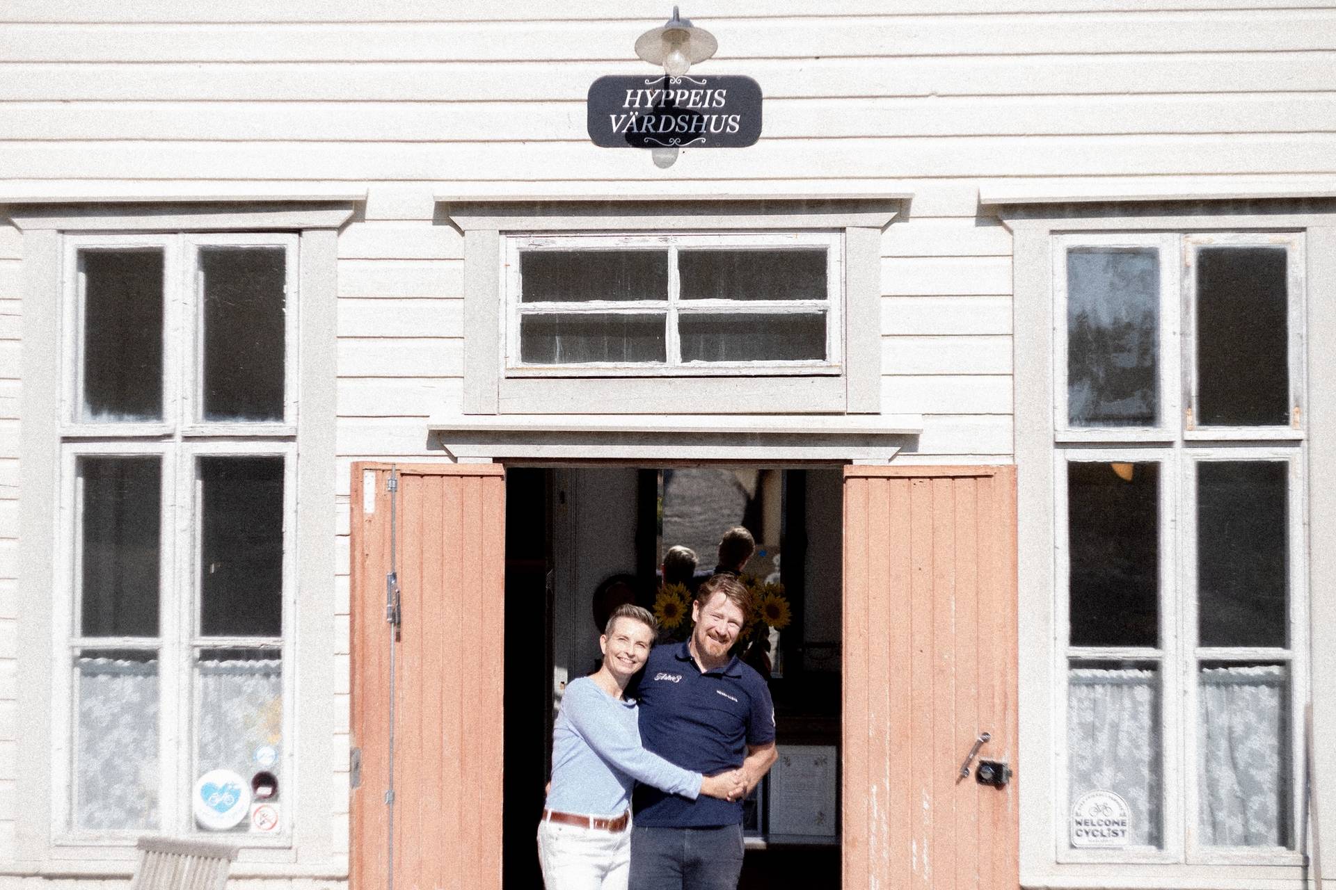 Hotel owners standing in a doorway.