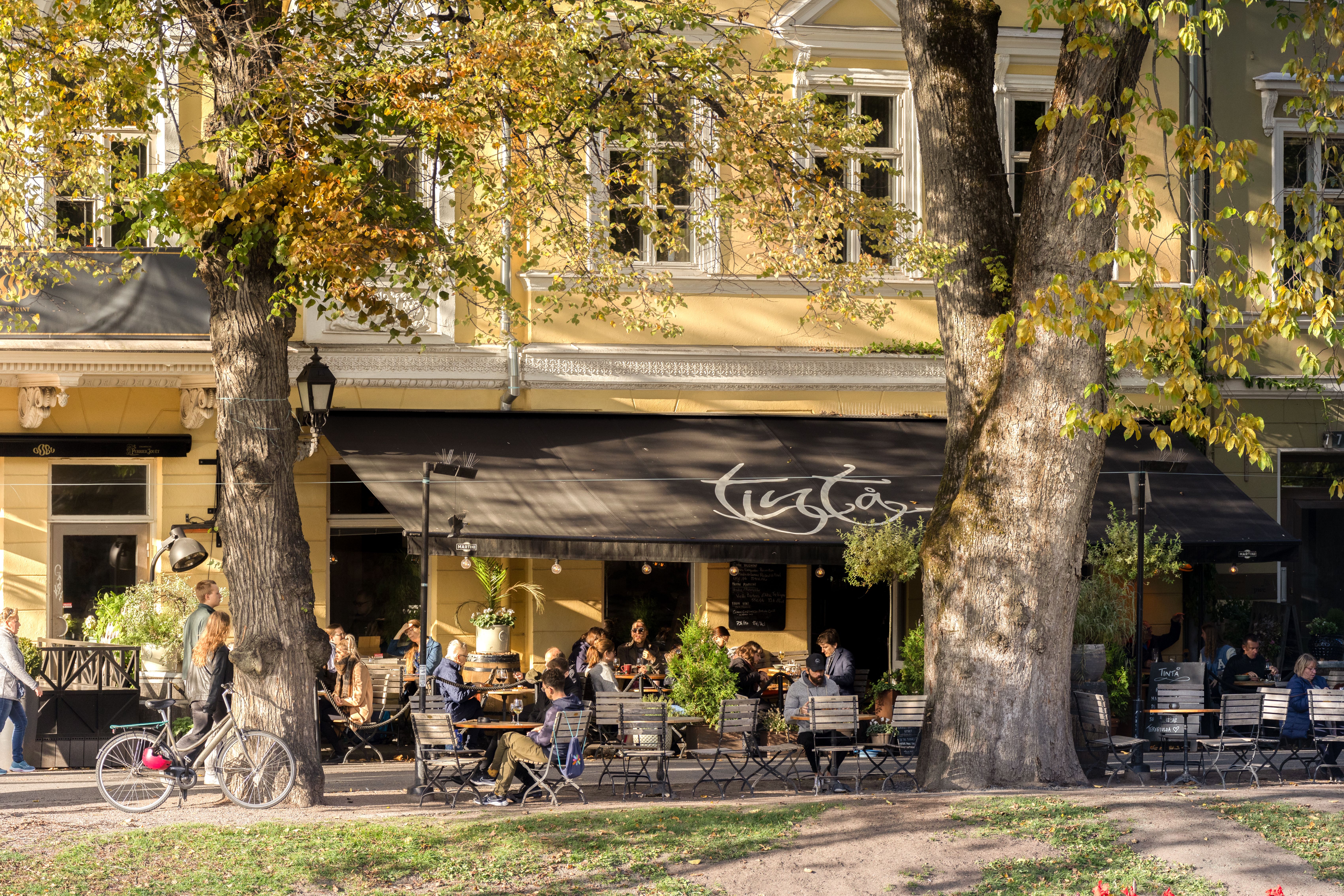 People drinking coffee along the Aura river