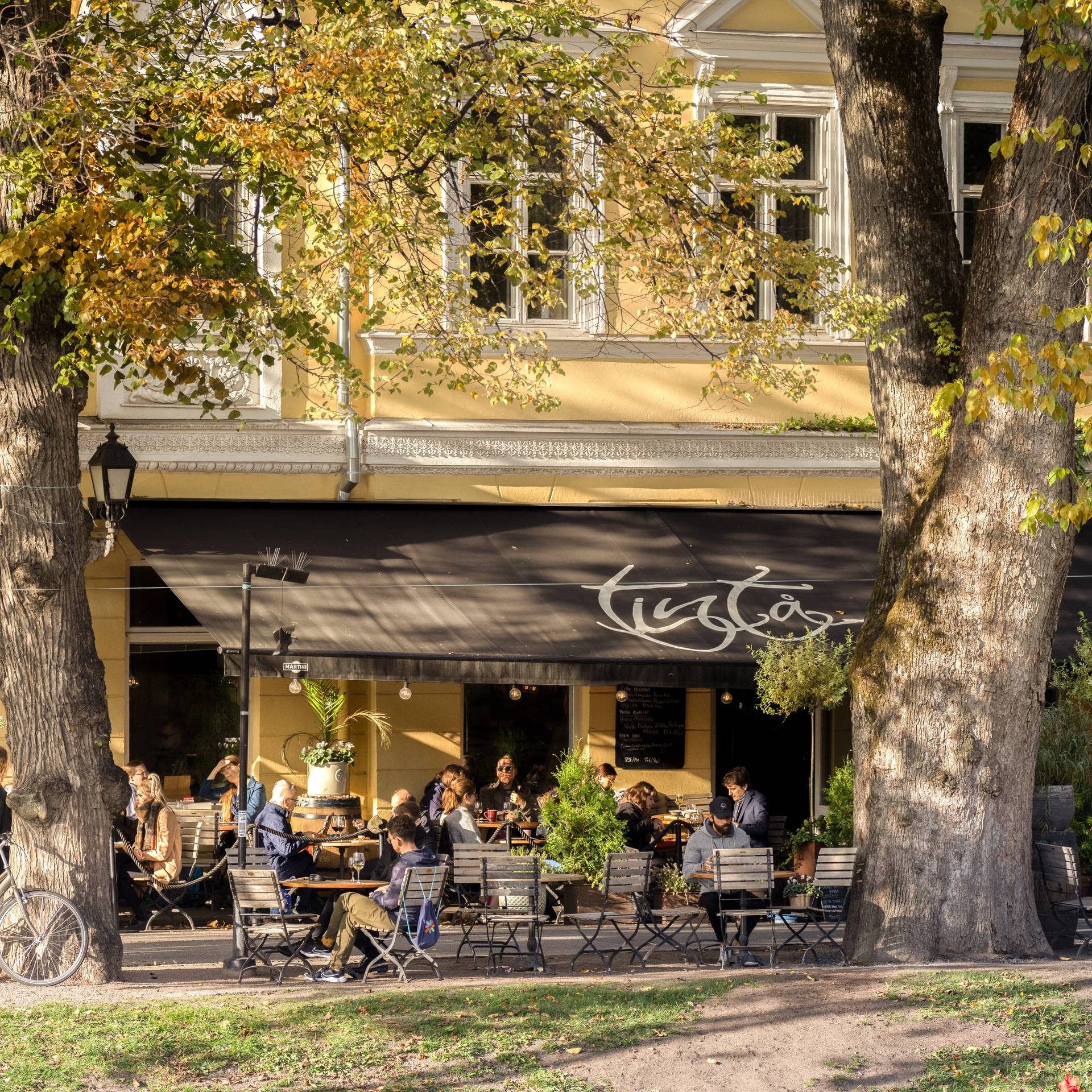 People drinking coffee along the Aura river