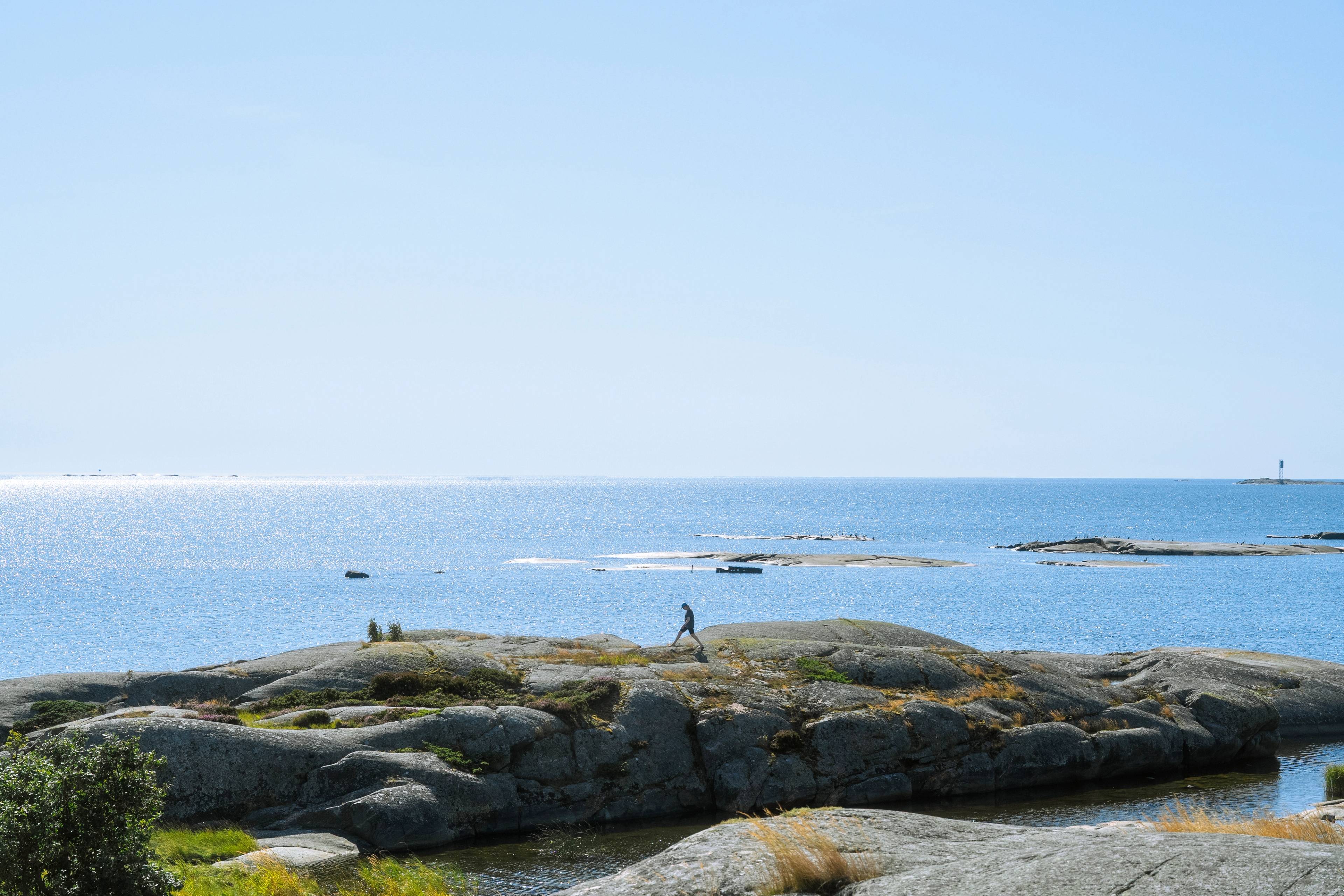 A person walking along the shore of the Baltic sea.