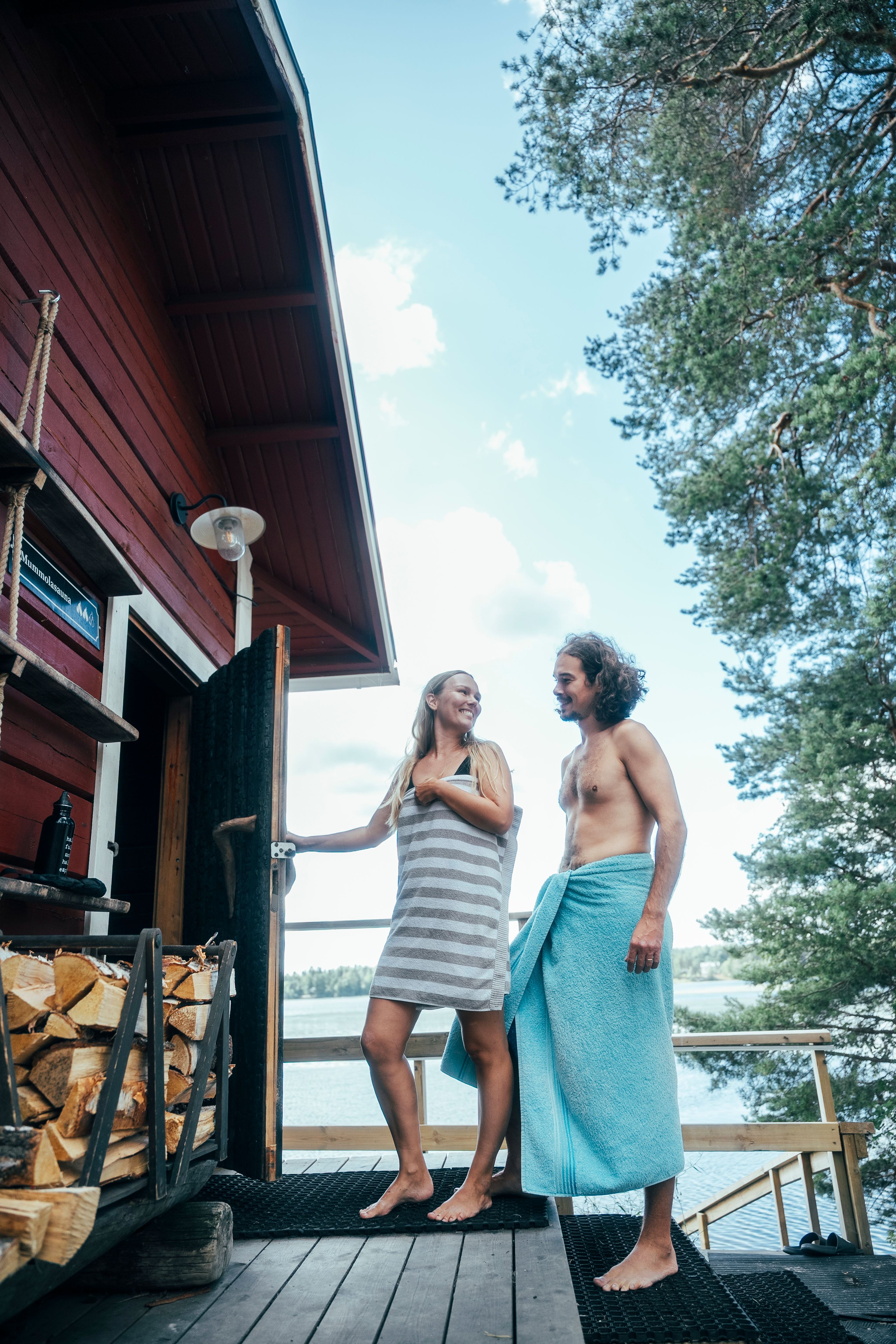 Two people entering a wooden sauna.