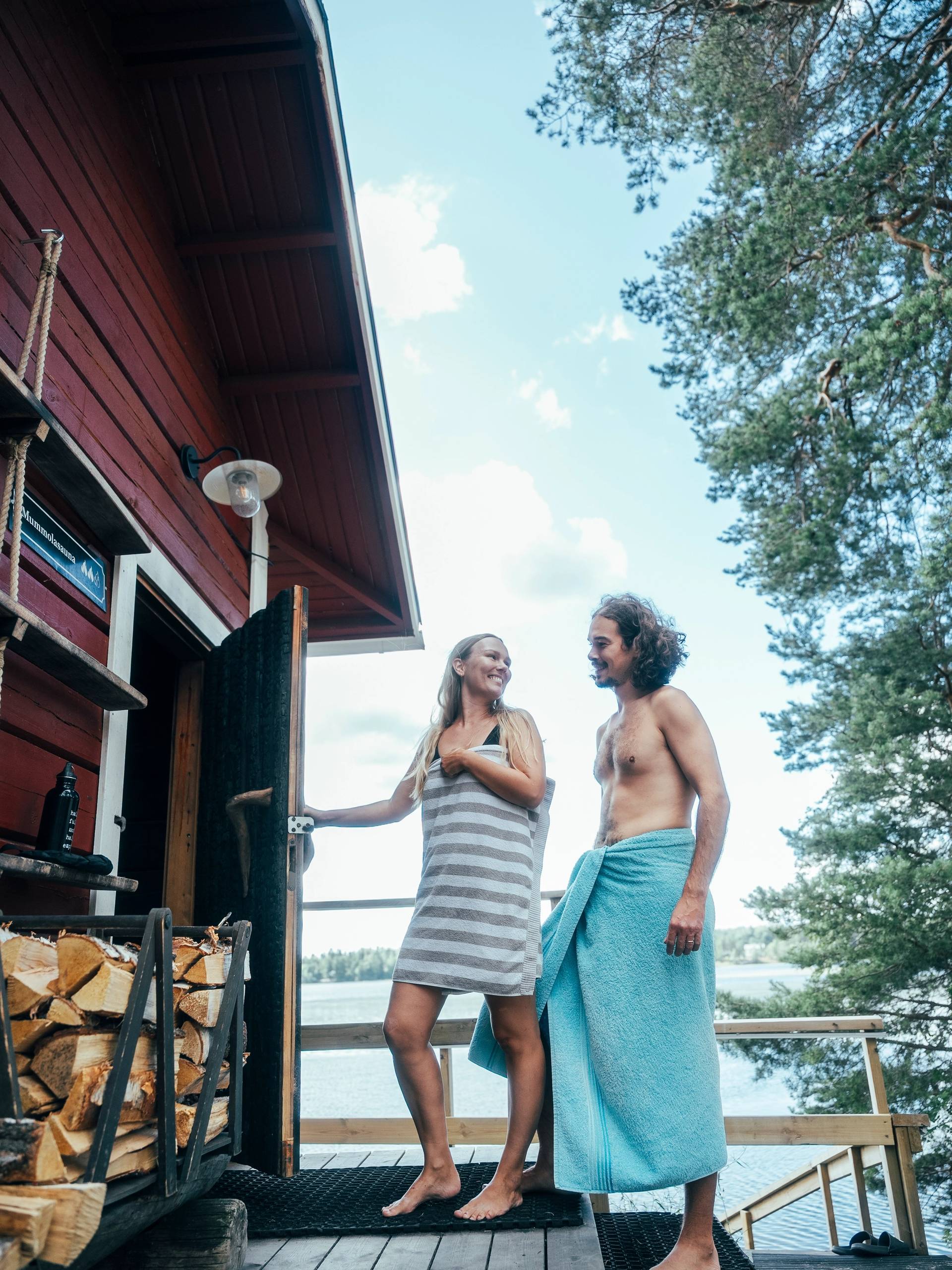 Two people entering a wooden sauna.