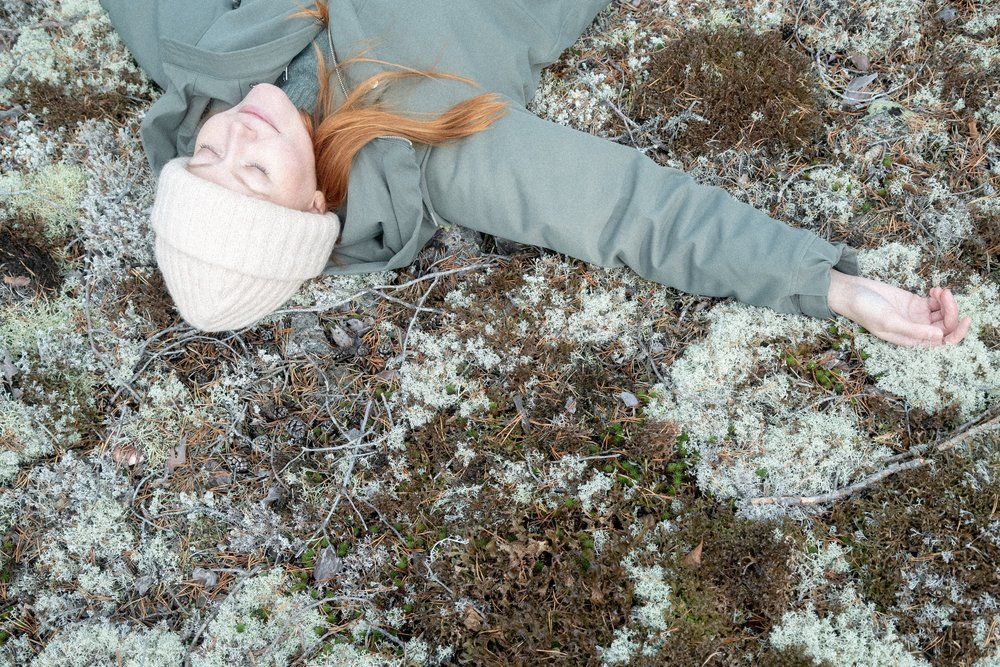 A girl resting on the forest floor.