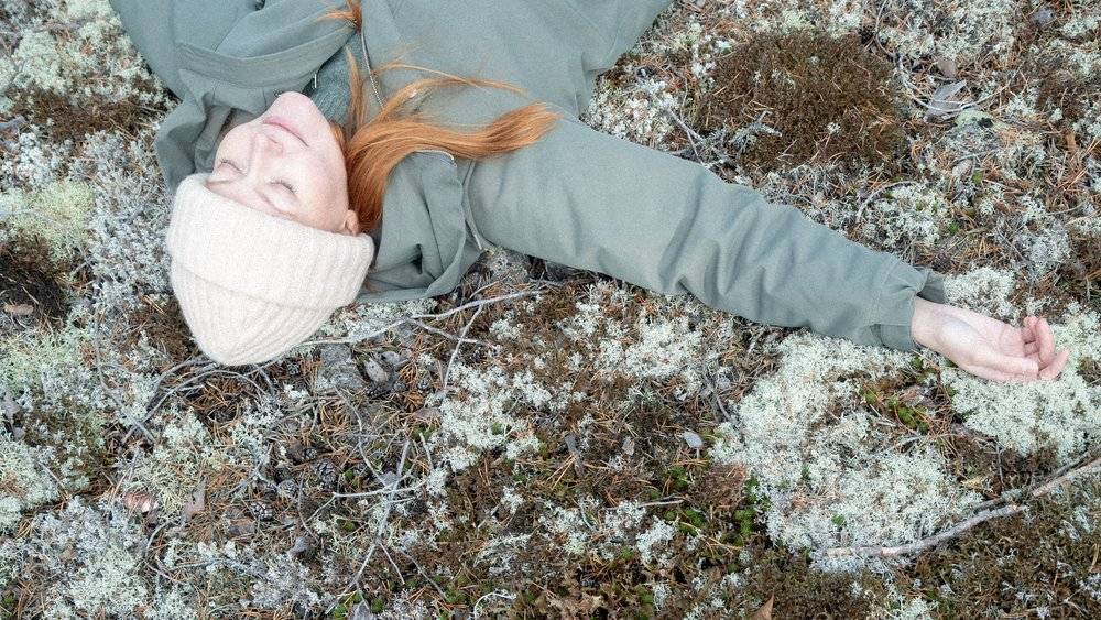 A girl resting on the forest floor.
