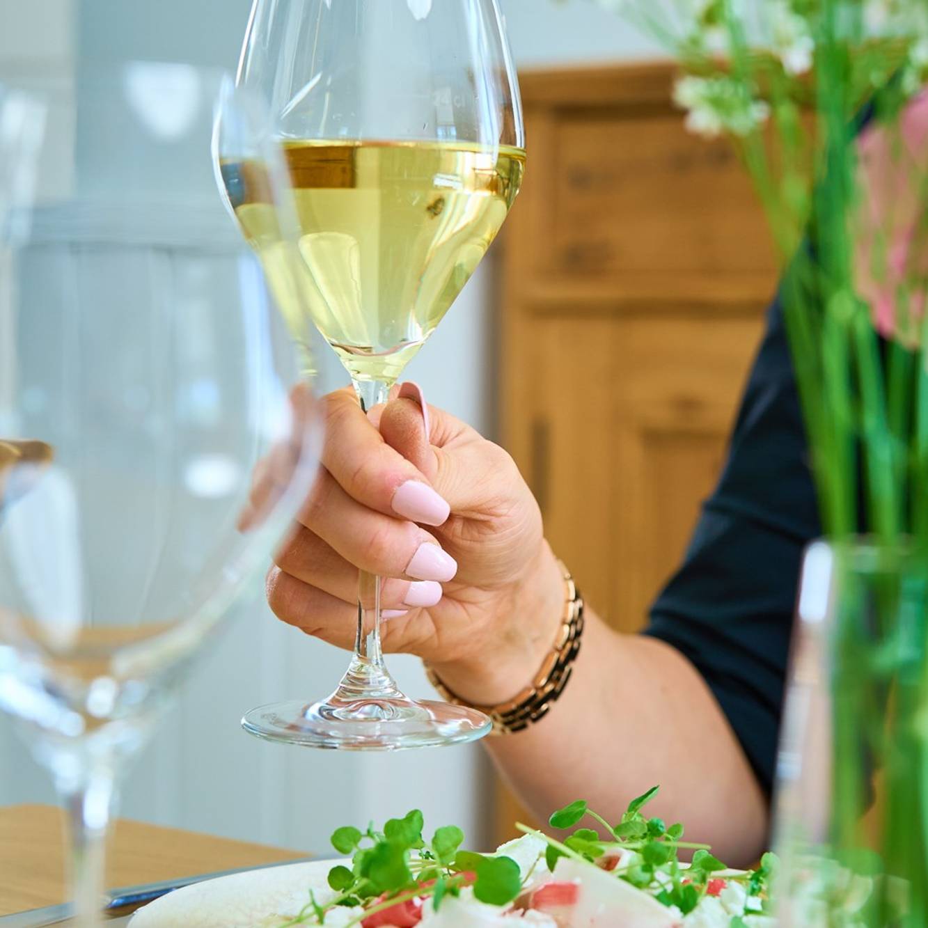 A wine glass and person dining