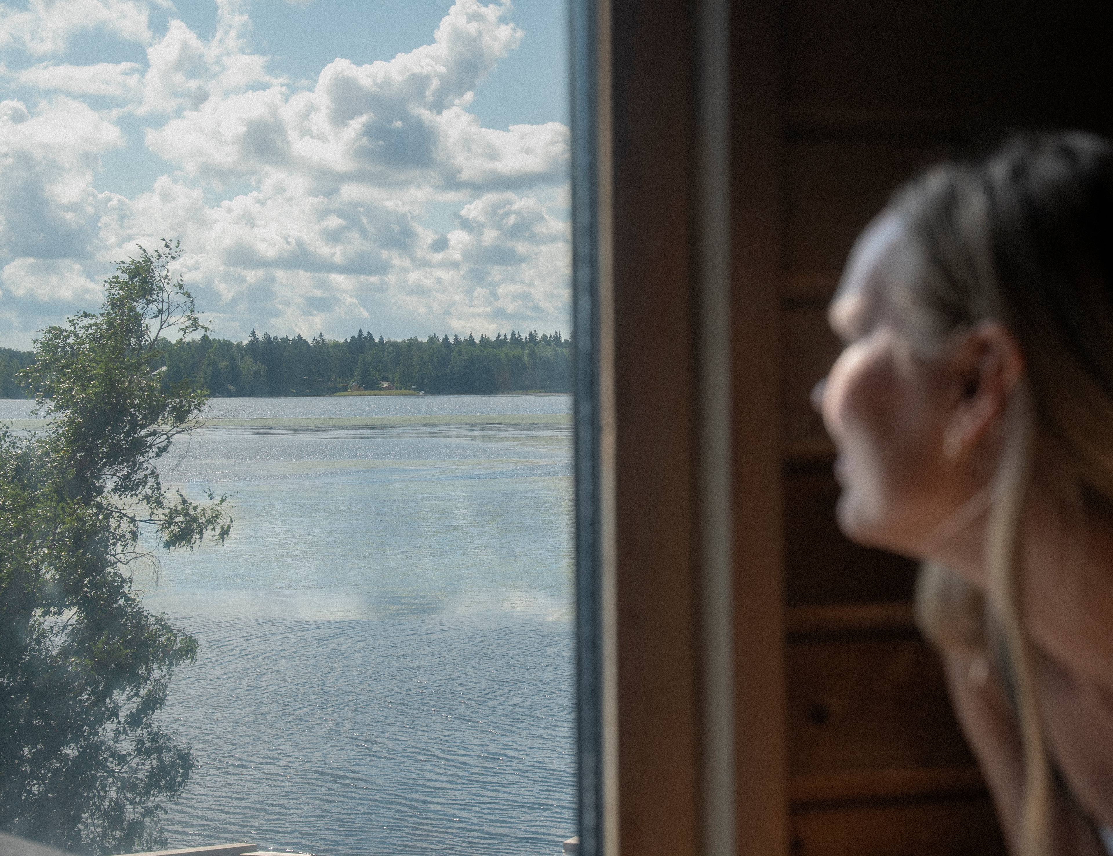 A woman gazing out a sauna window.