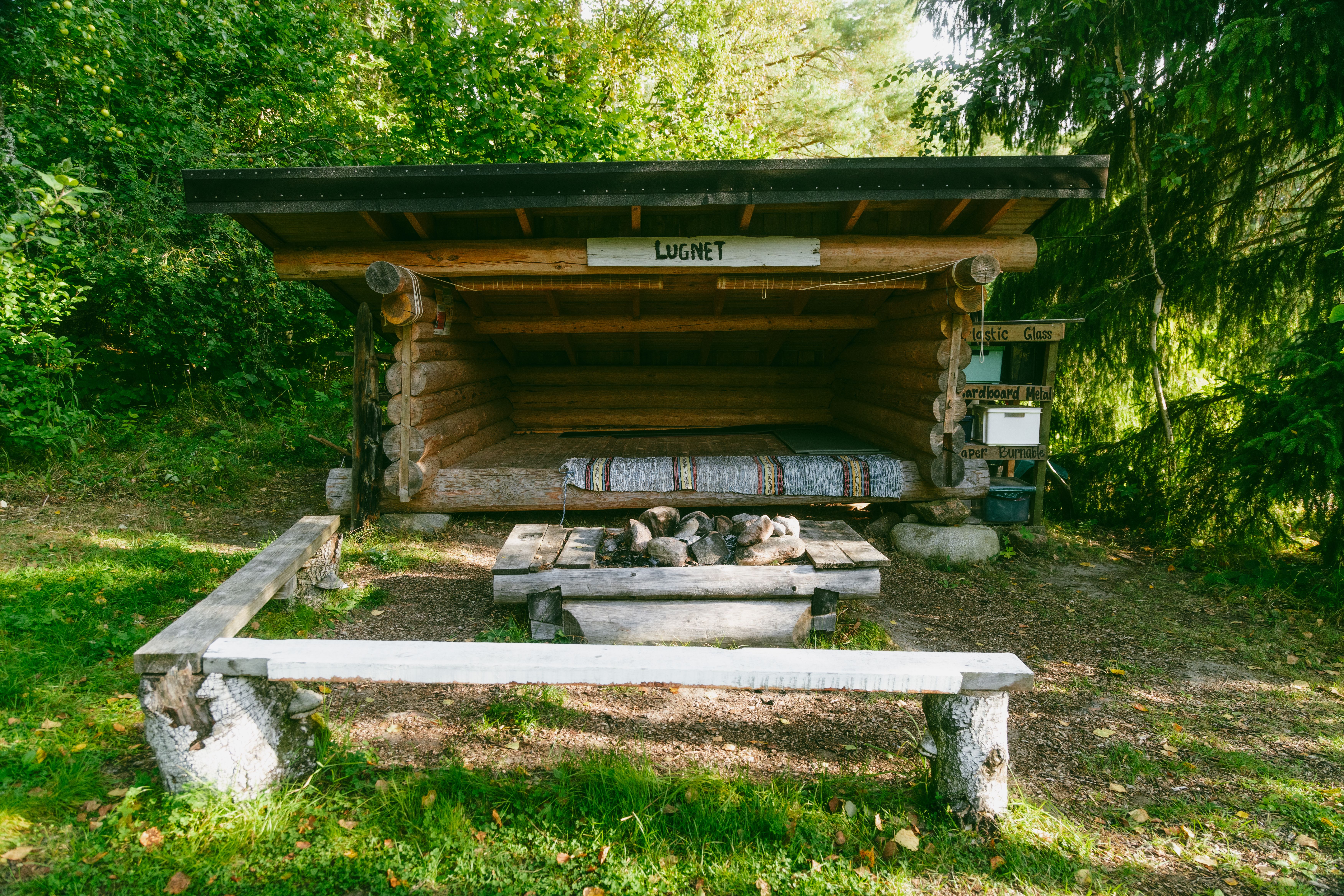 An outdoor hut in the woods.