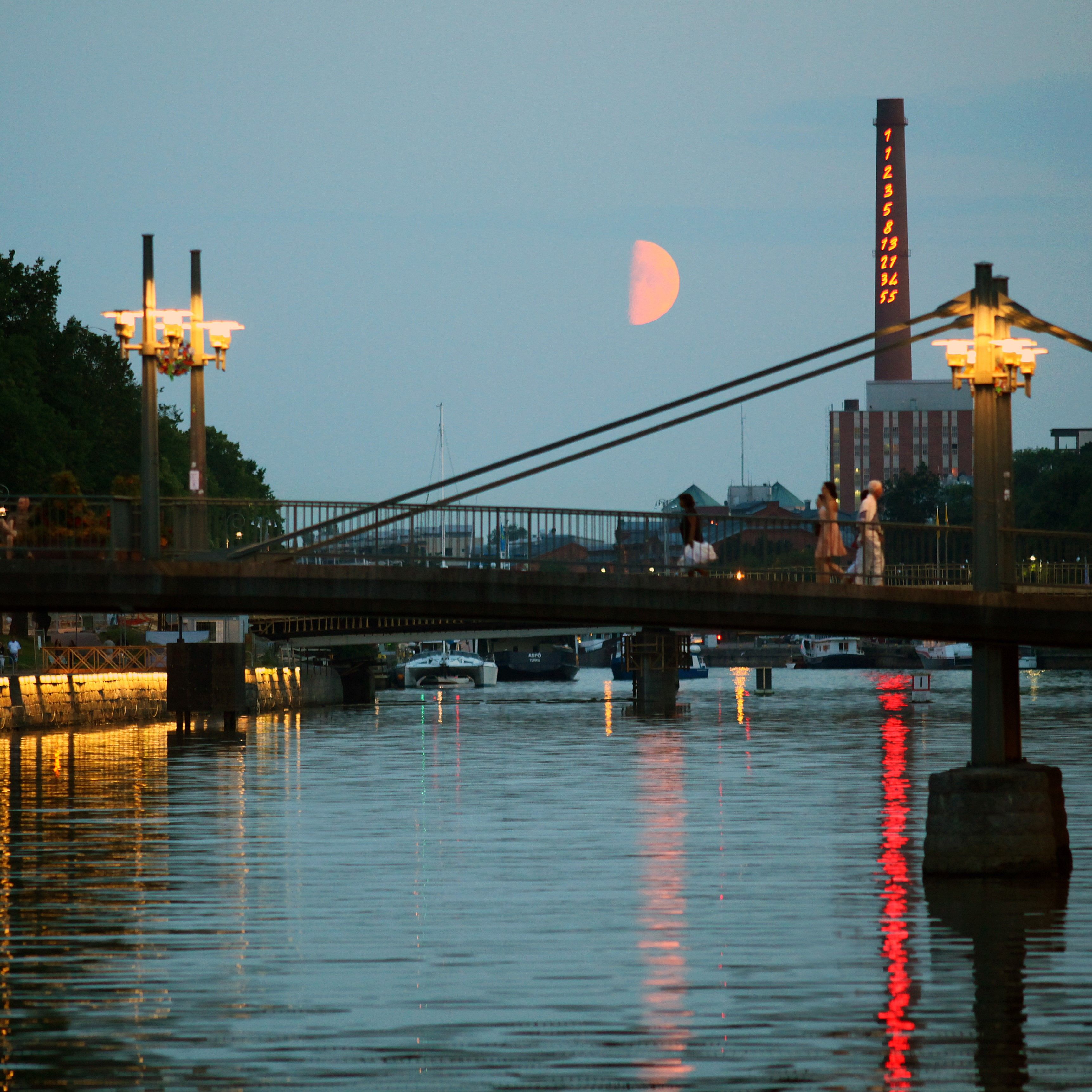 A view of a bridge over the river on a summer evening