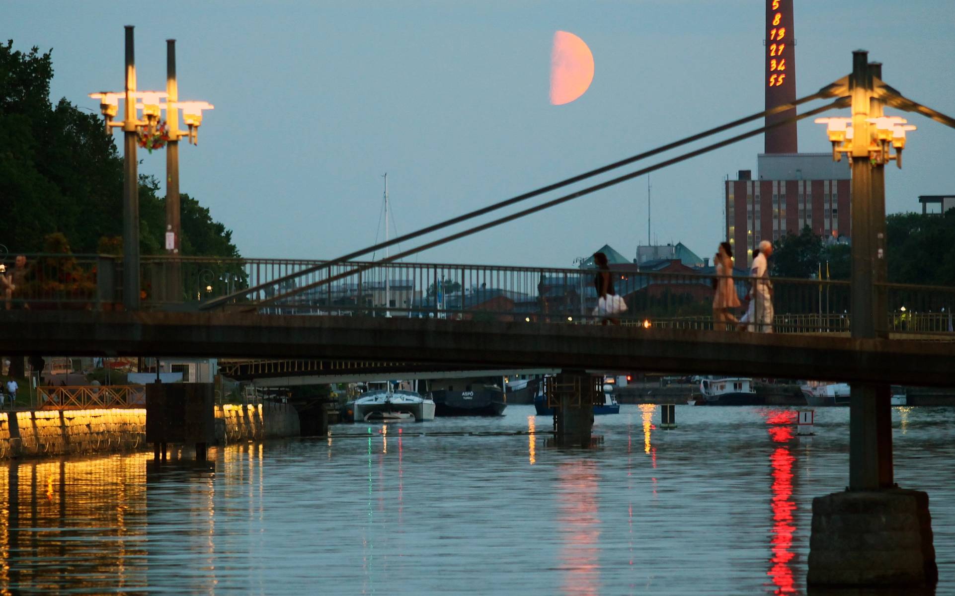 A view of a bridge over the river on a summer evening