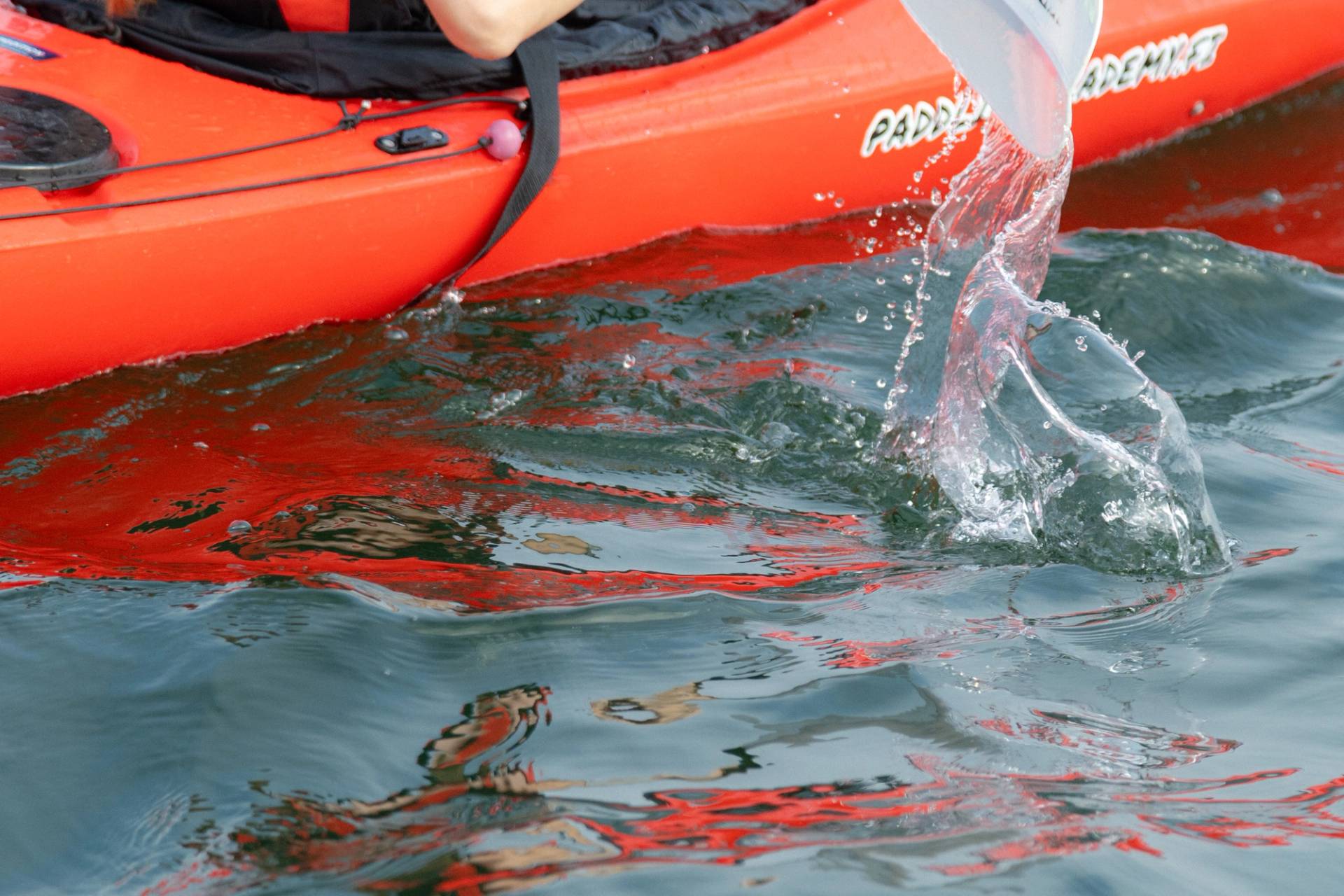 A red kayak moving on the water.