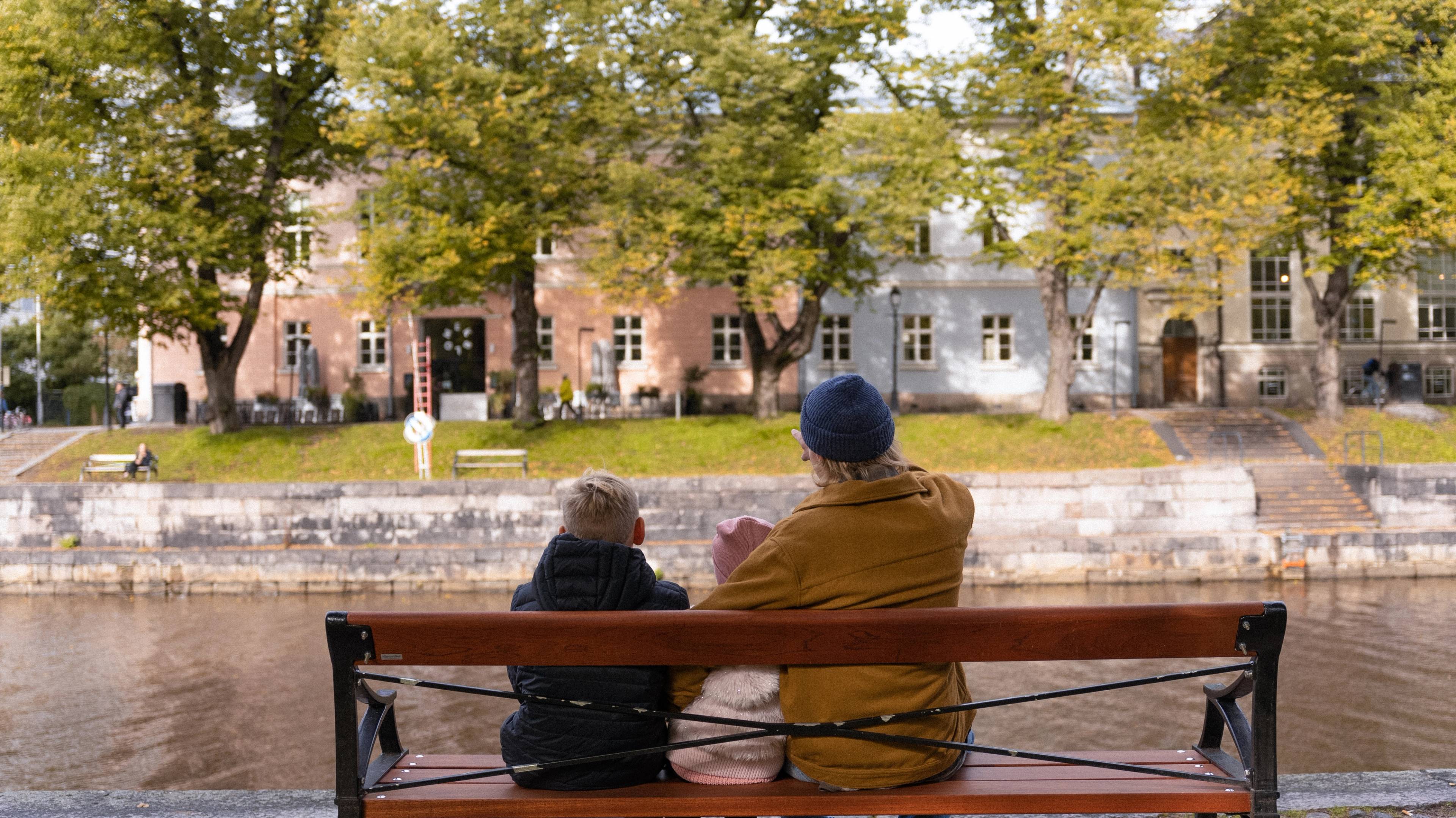 An adult person pointing at an array of traditional houses across the canal