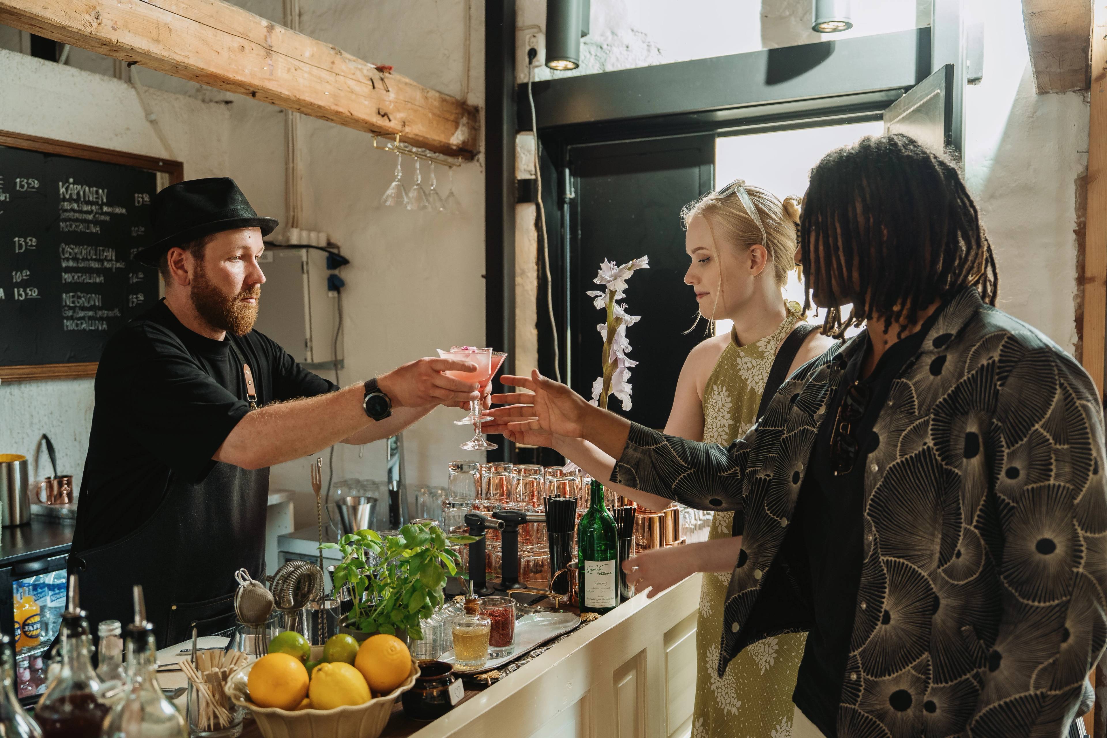 Two people being served cocktails.
