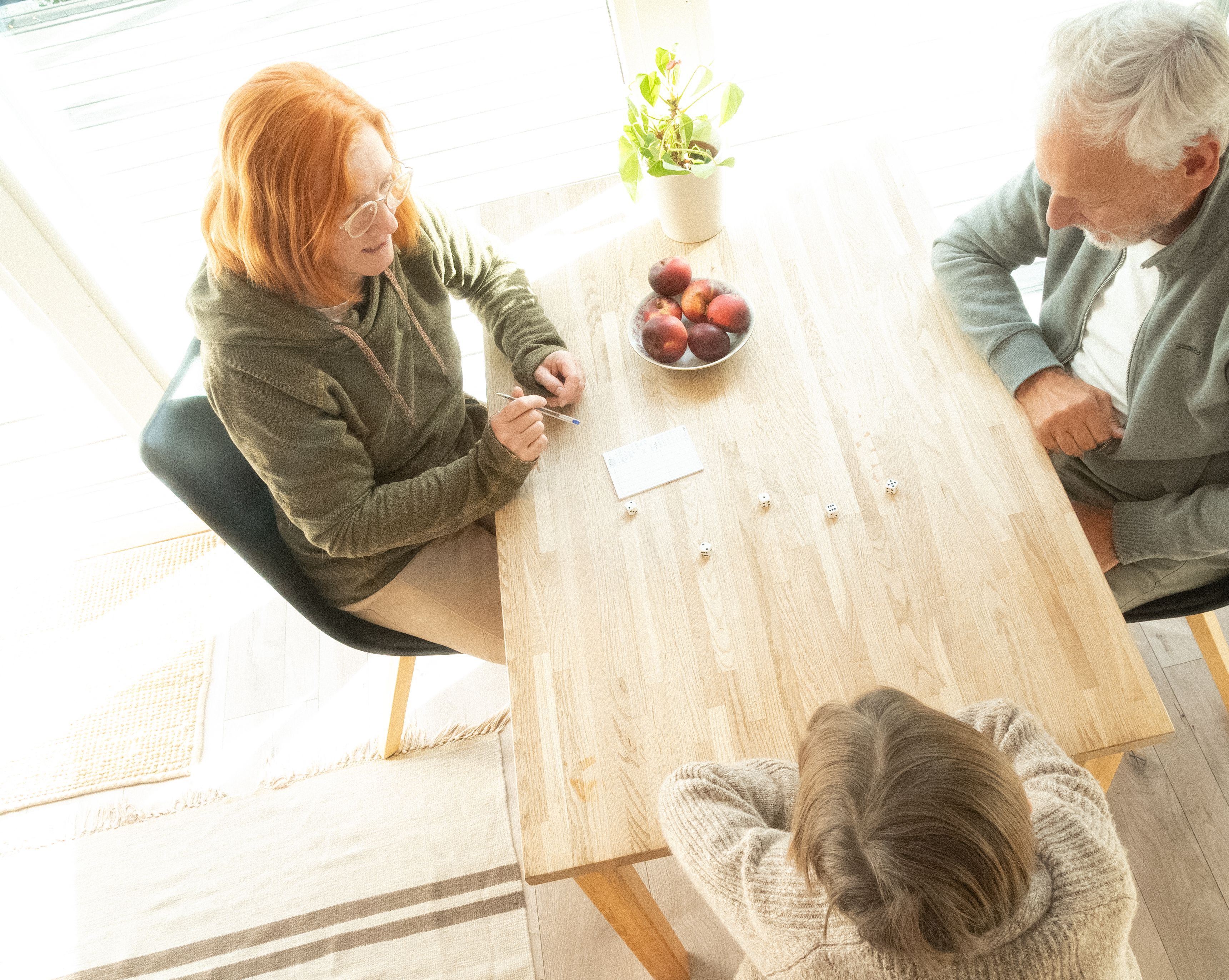 Peope playing a dice game in a cottage.