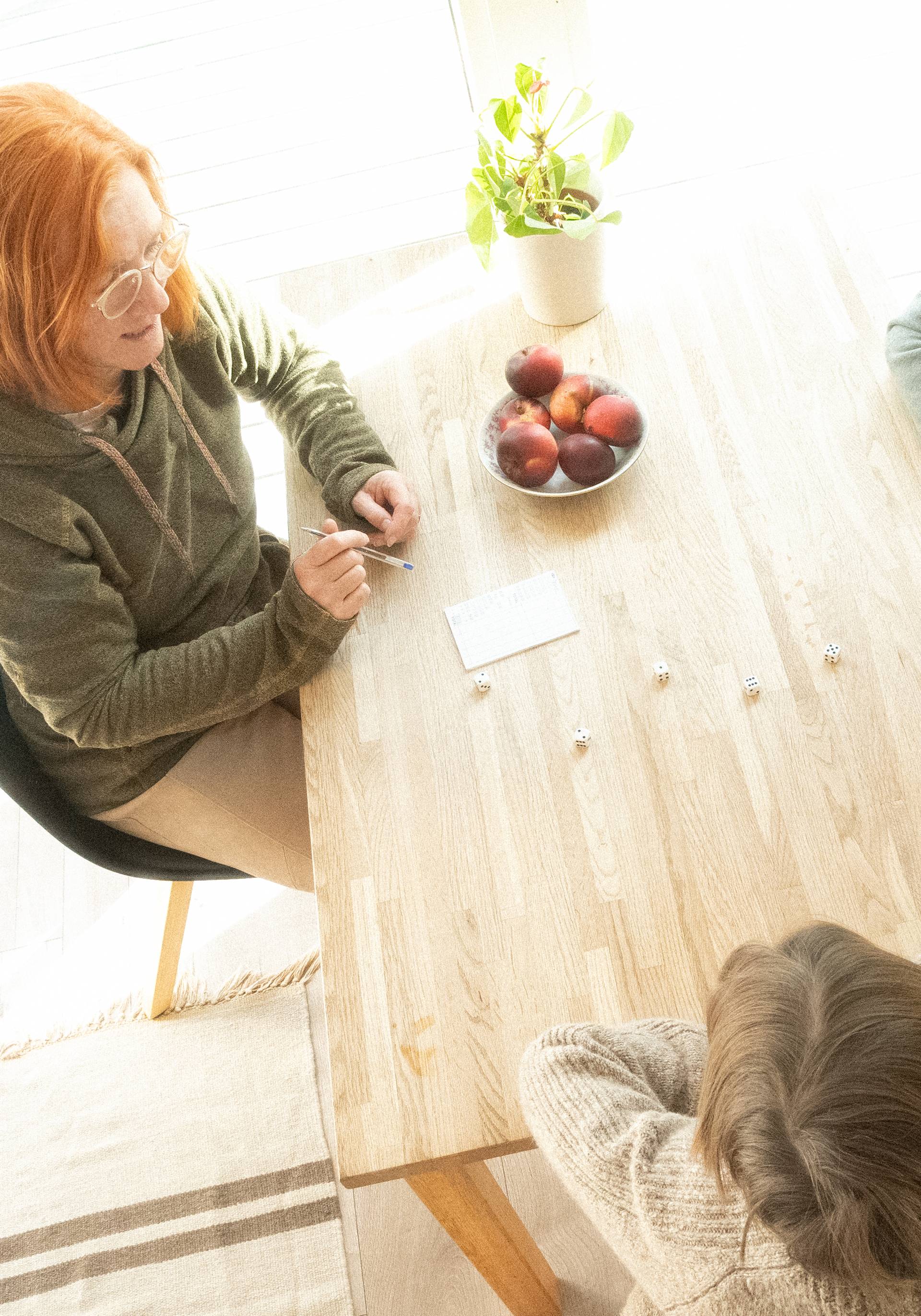 Peope playing a dice game in a cottage.