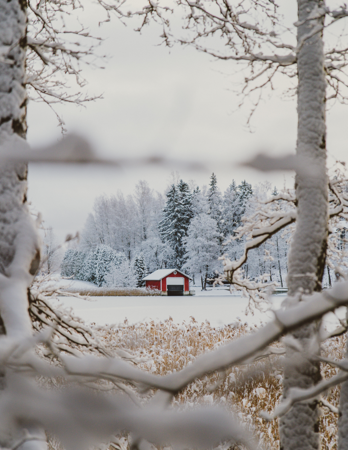 A red building in the middle of a snowy field.
