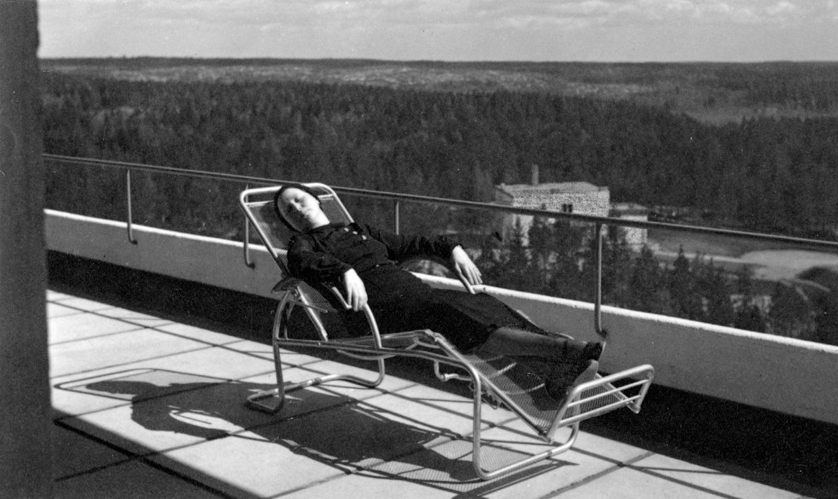 A patient laying on the balcony in a historic photo of the Paimio Sanatorium