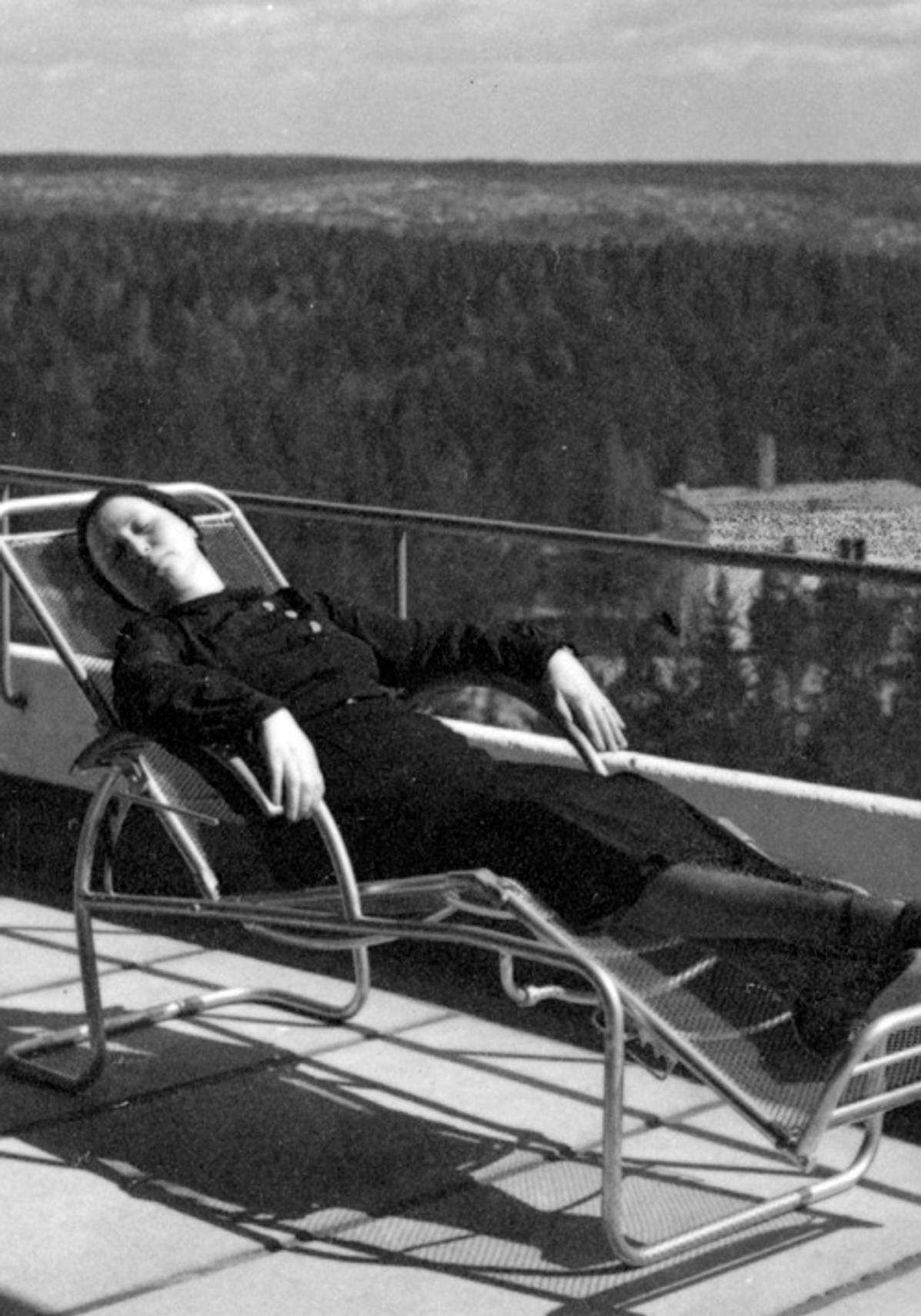 A patient laying on the balcony in a historic photo of the Paimio Sanatorium