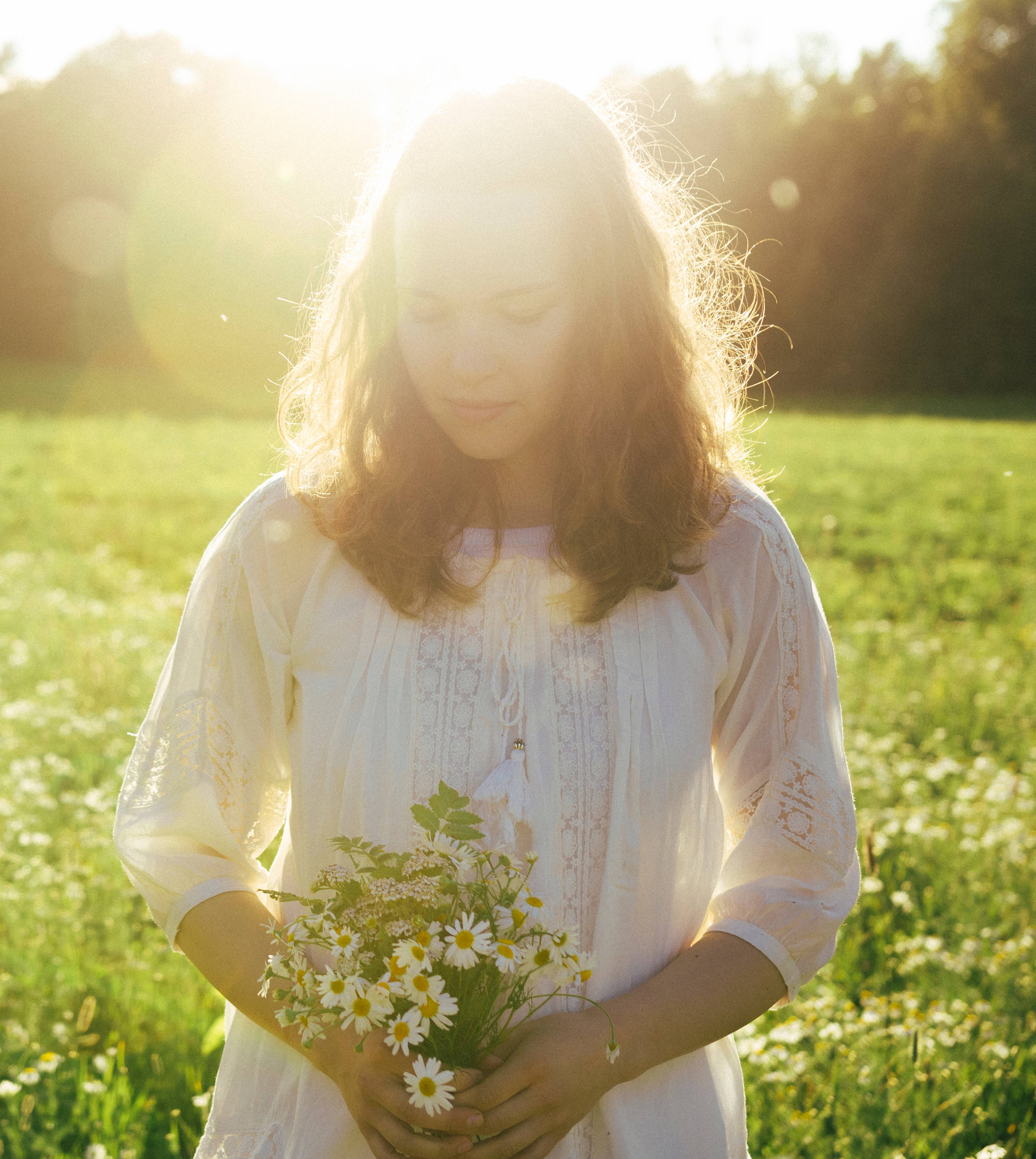 A girl holding a bundle of flowers.
