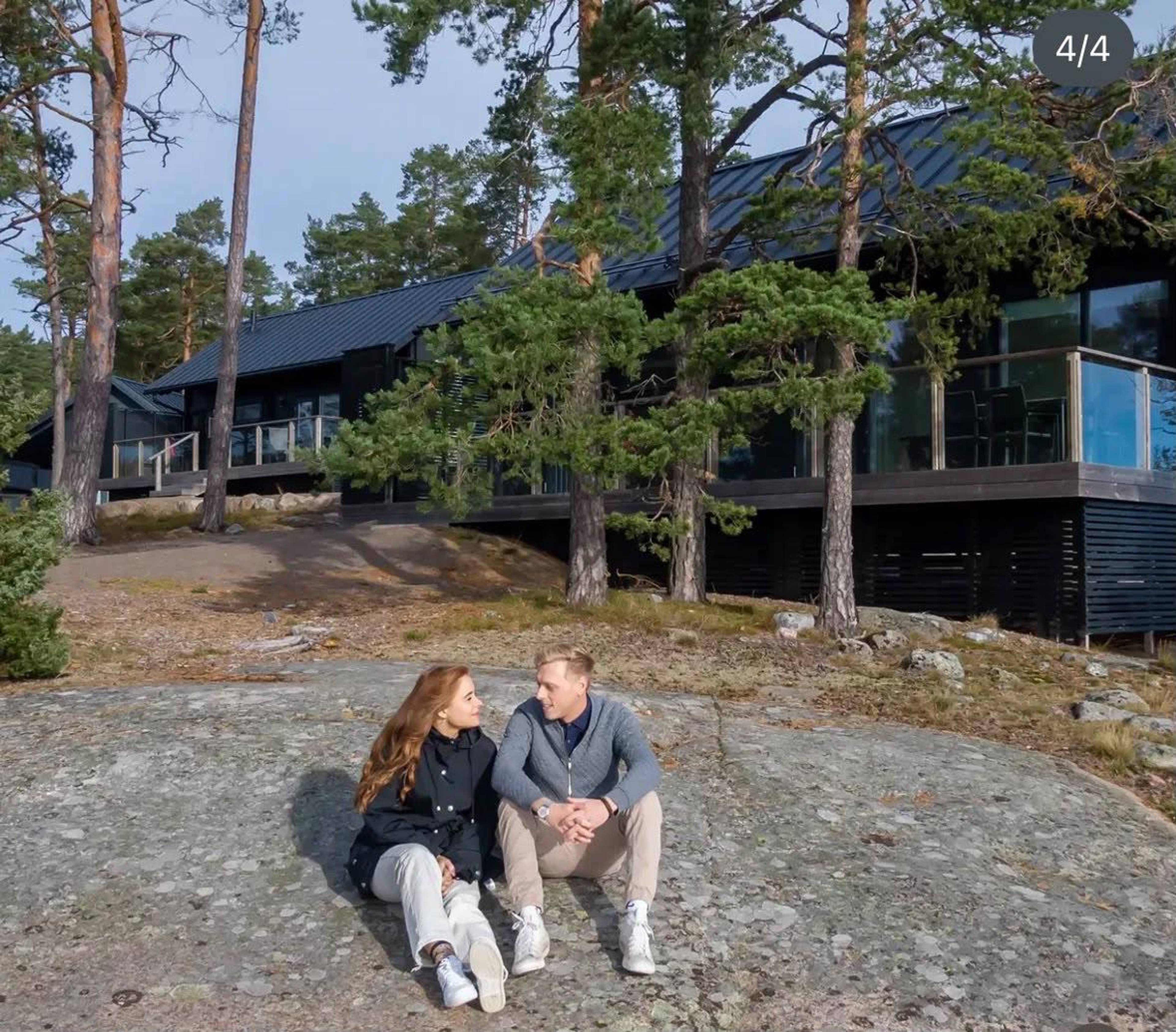 Two people sitting in front of an island accommodation.