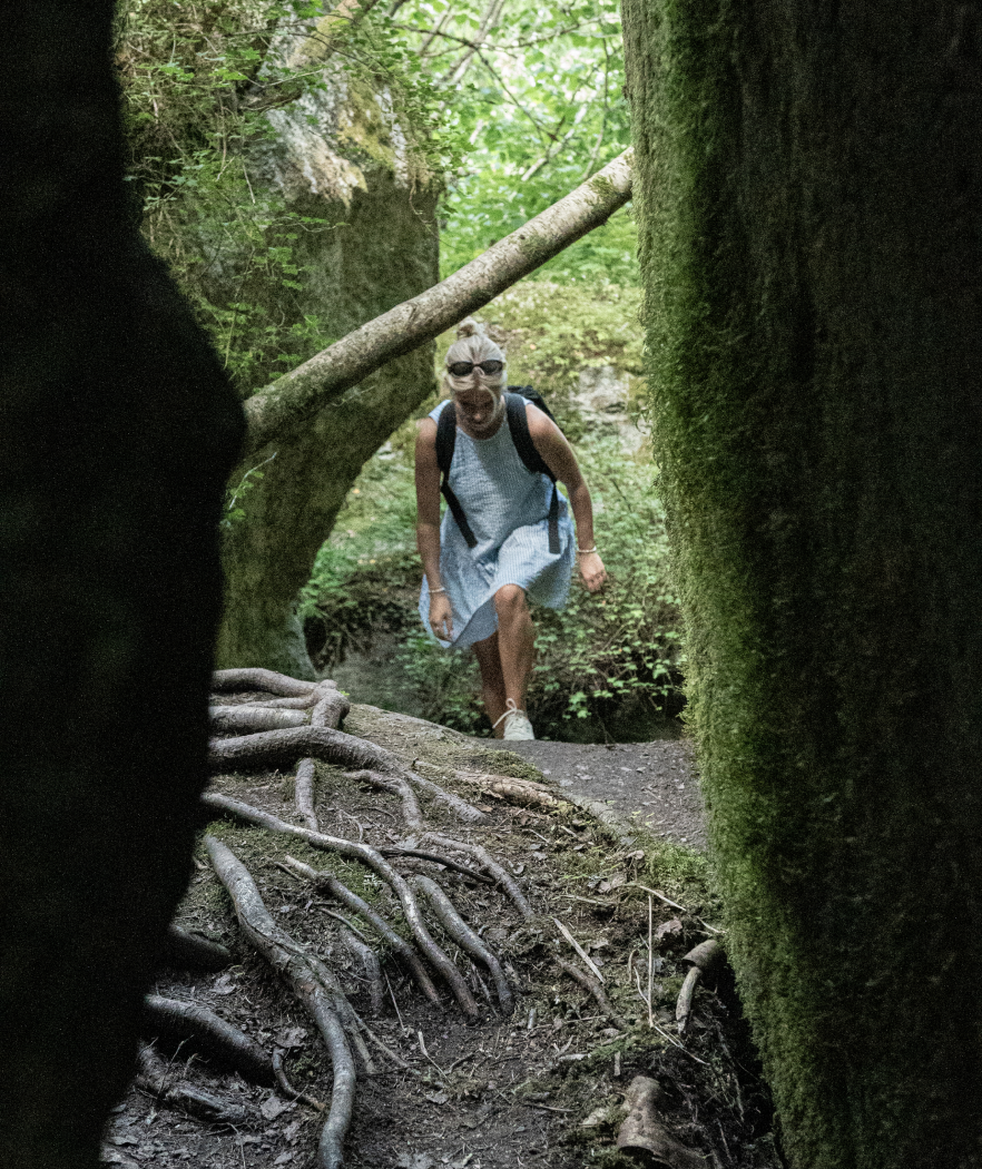 A woman walking in a dense forest.