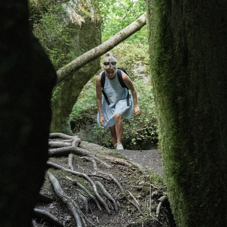 A woman walking in a dense forest.