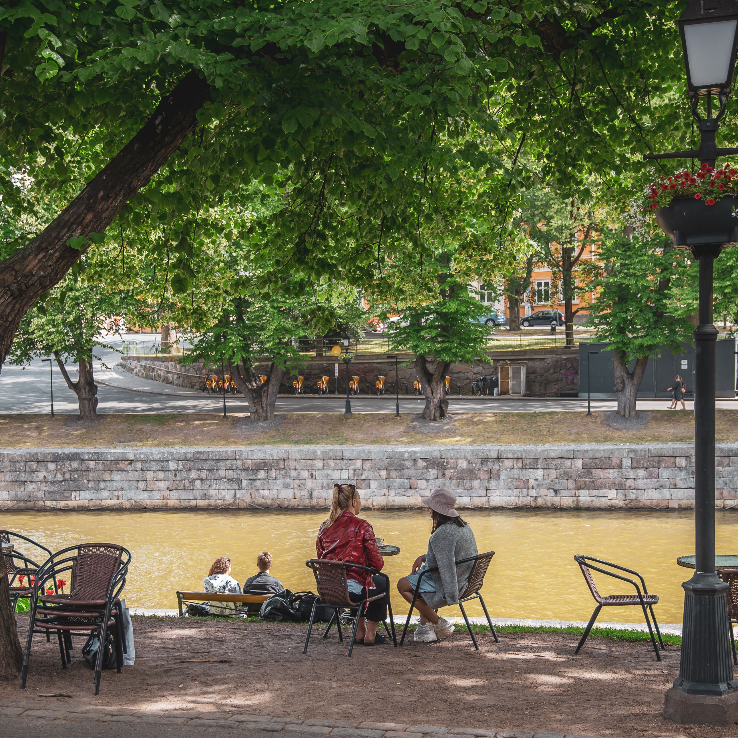 People sitting on the shore of Aurajoki