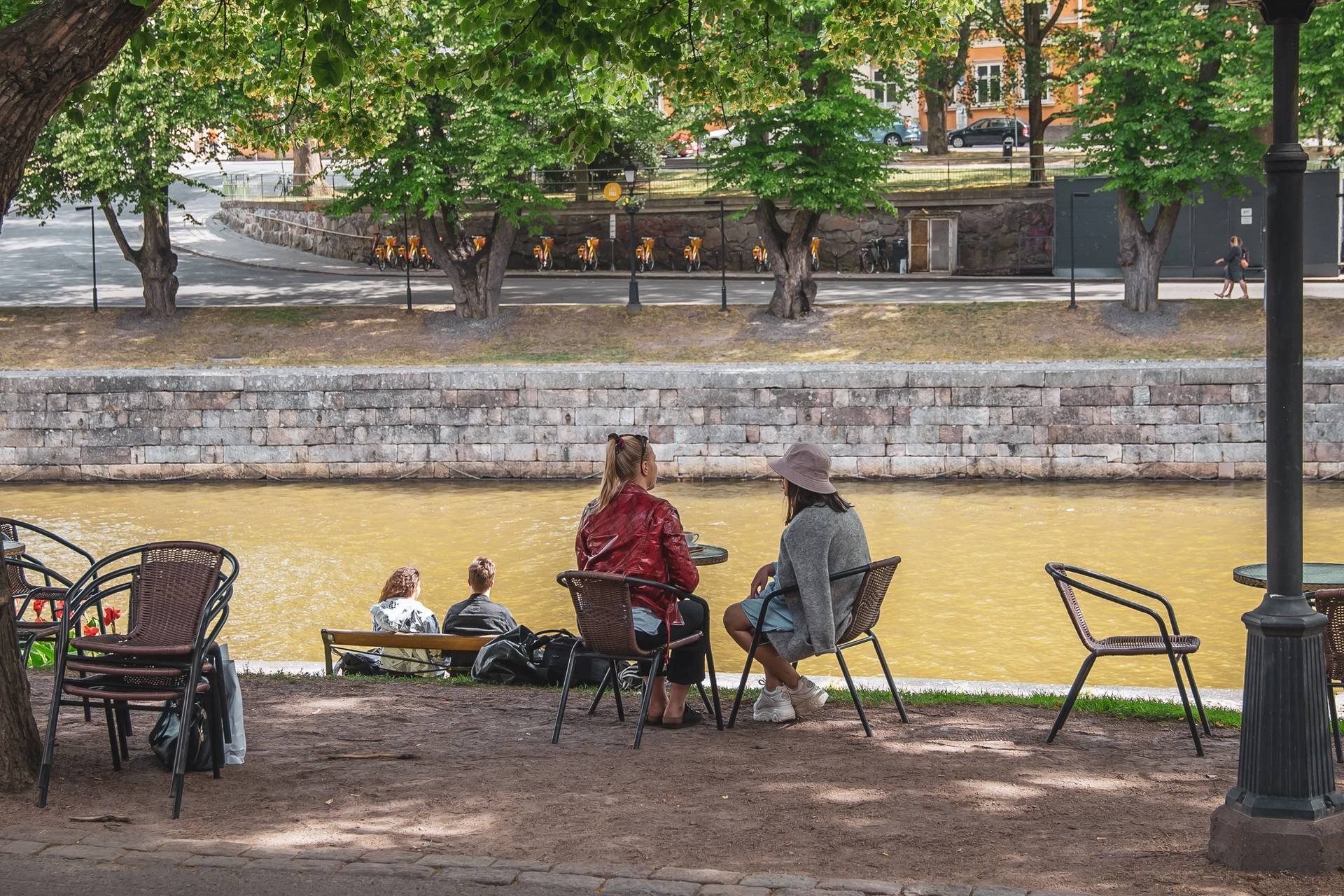 People sitting on the shore of Aurajoki
