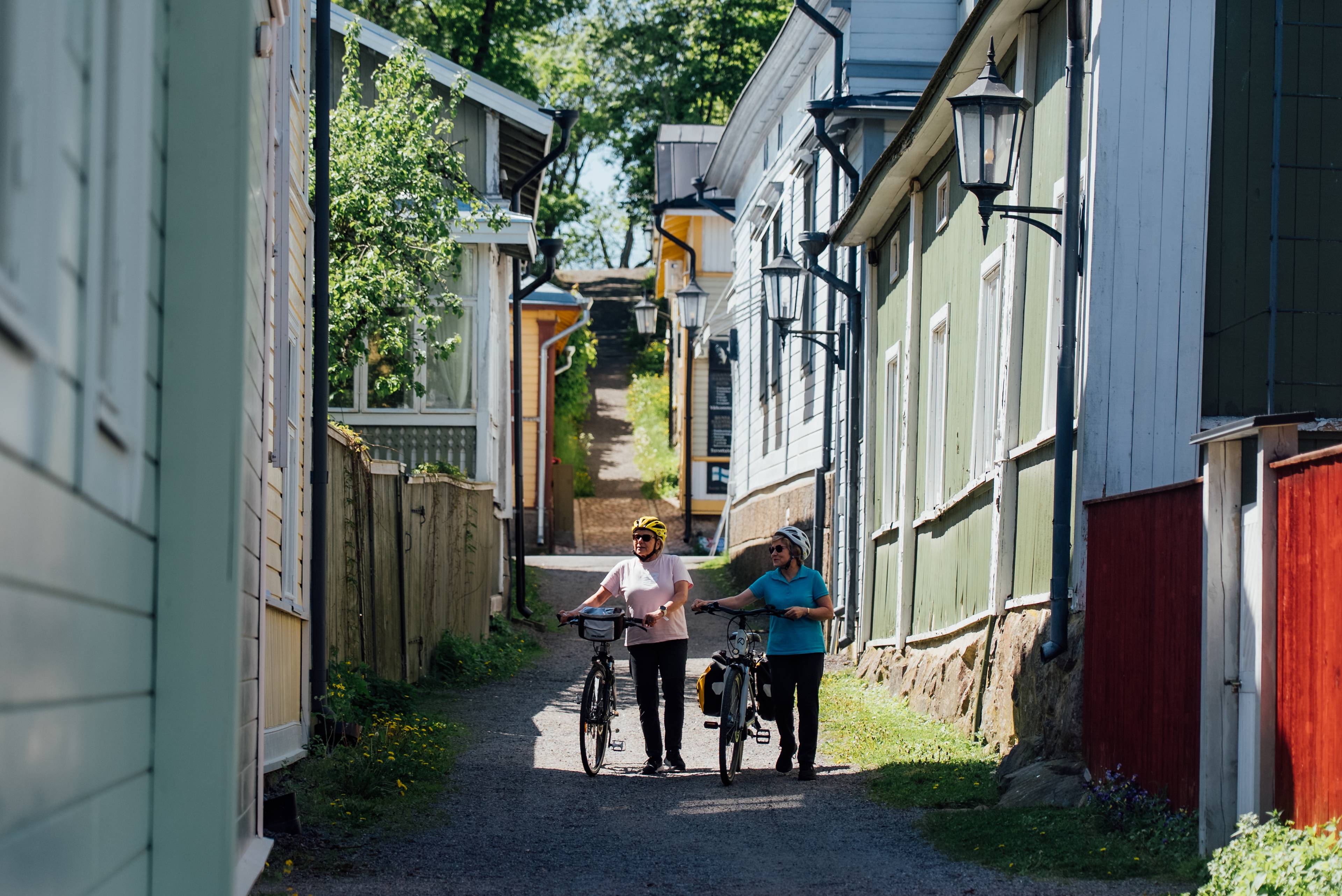 Two people walking with their bikes in Naantali old town.