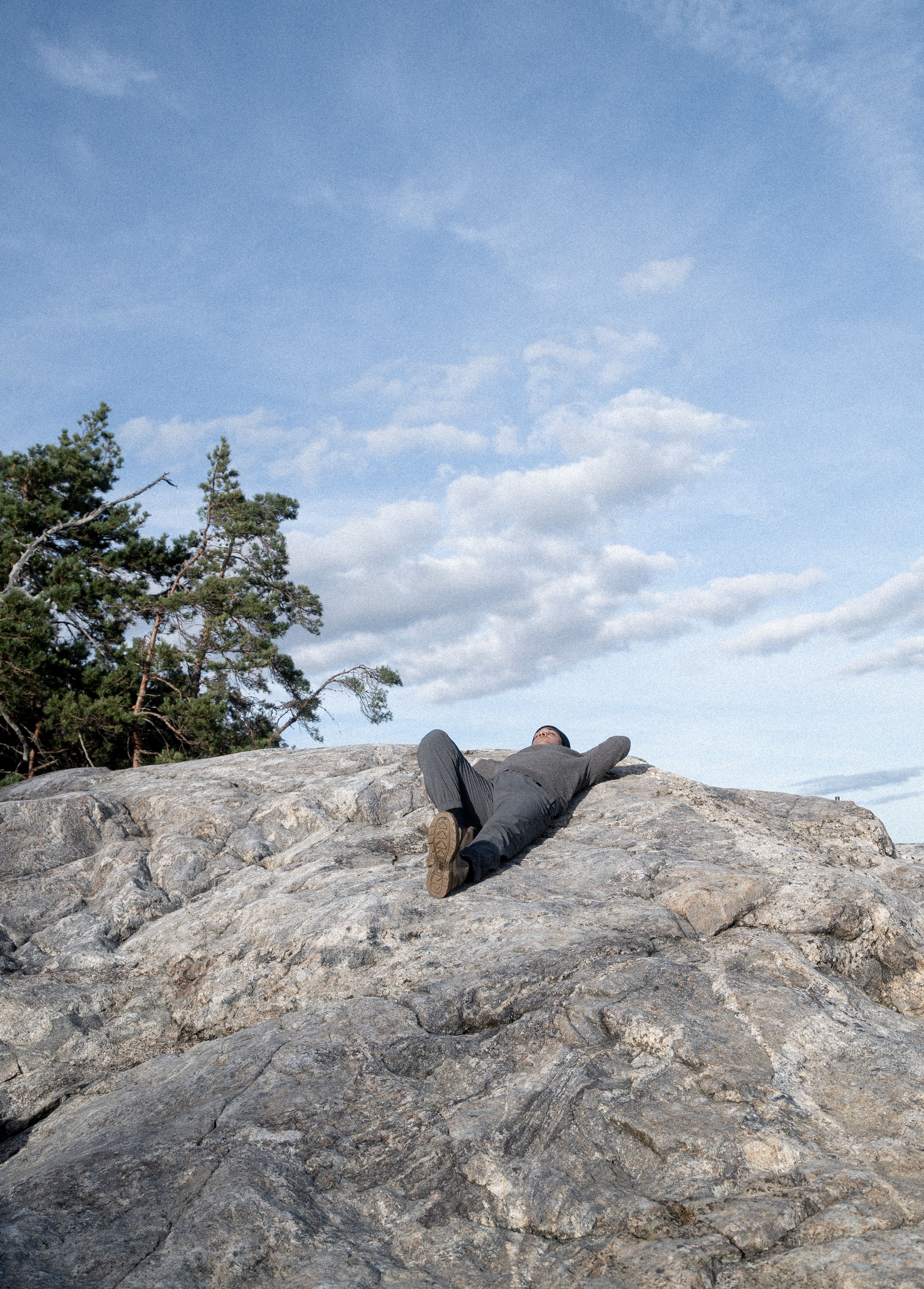 A person lying on the rocky shore.