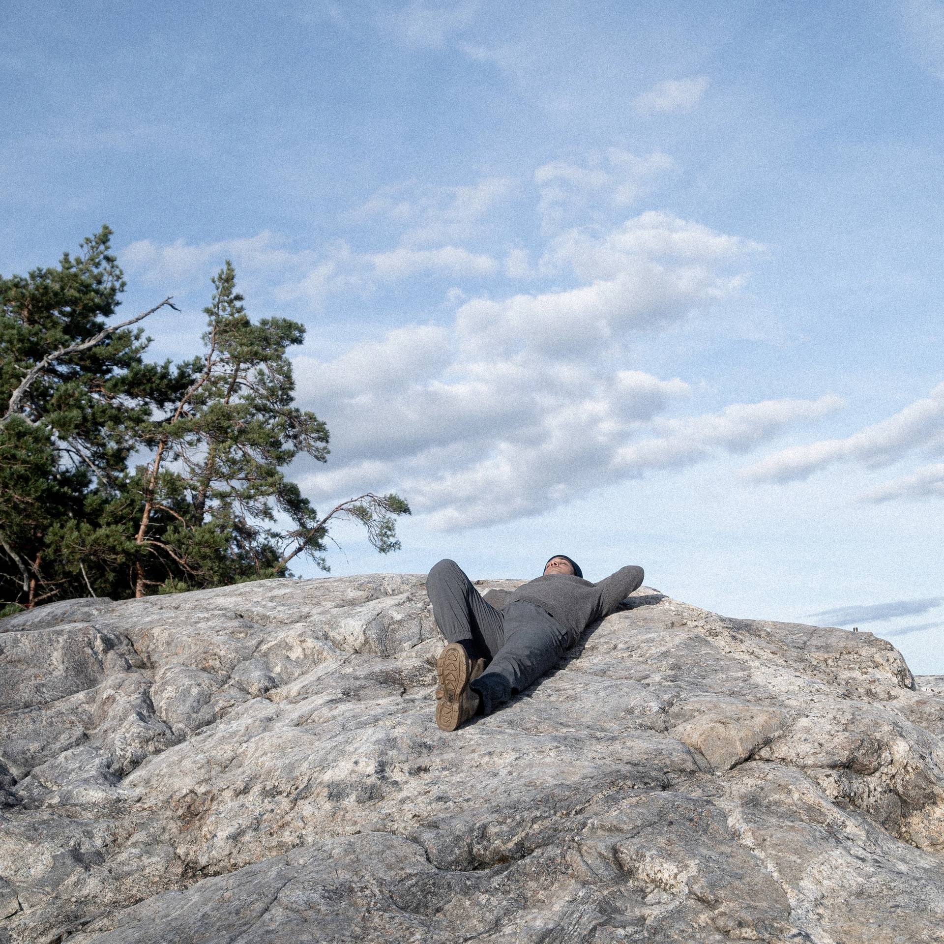 A person lying on the rocky shore.