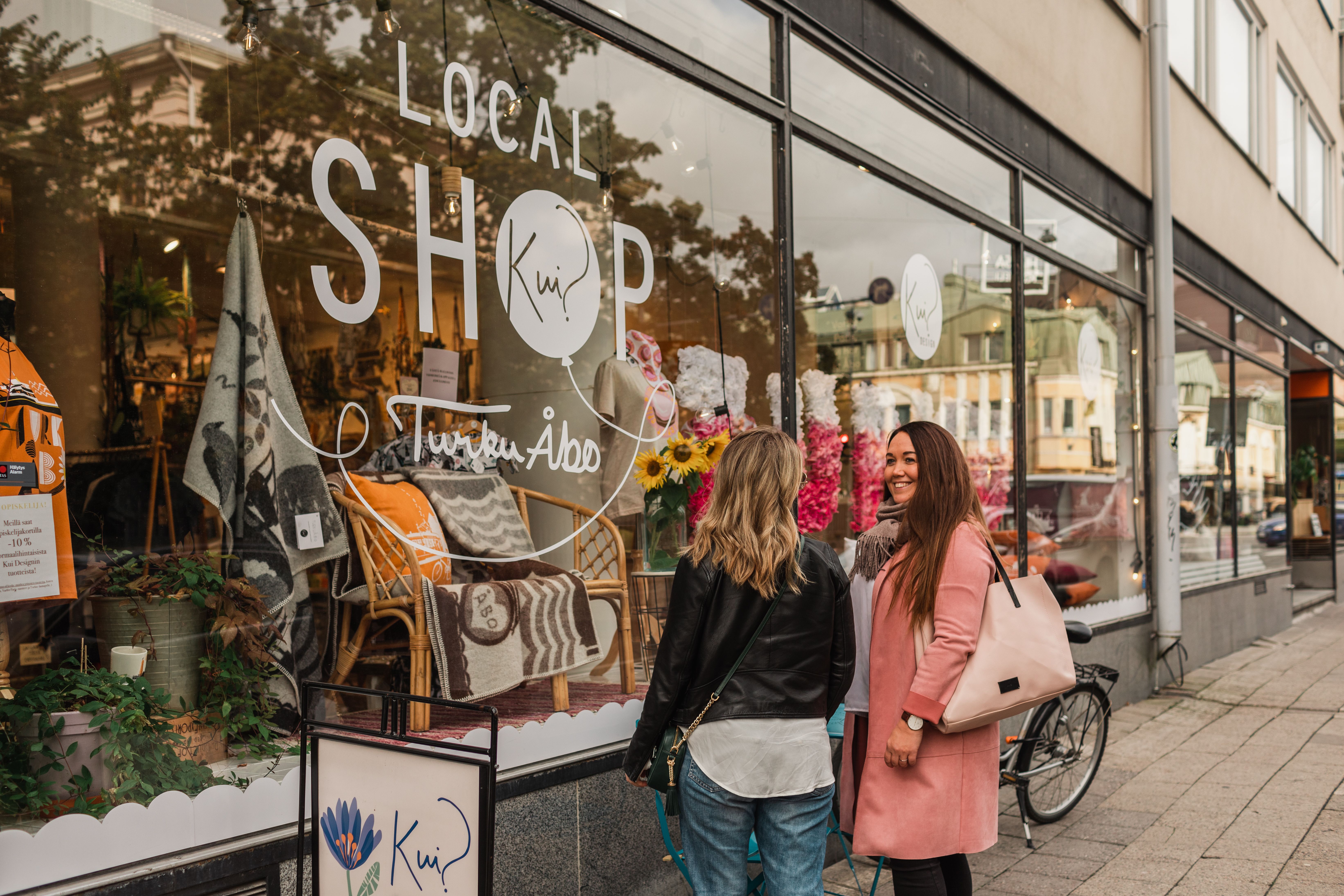 People window-shopping in front of a local shop in Turku.