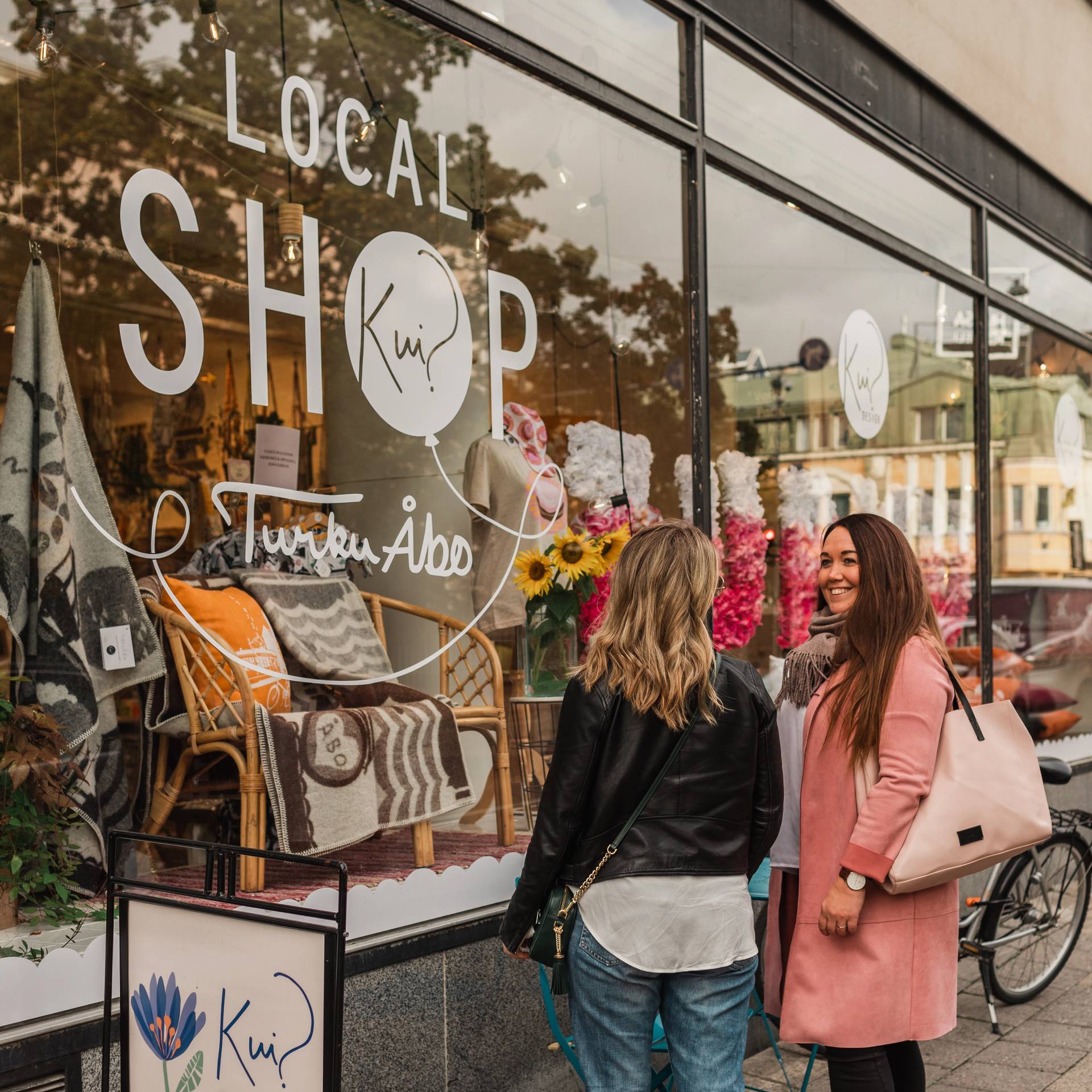 People window-shopping in front of a local shop in Turku.